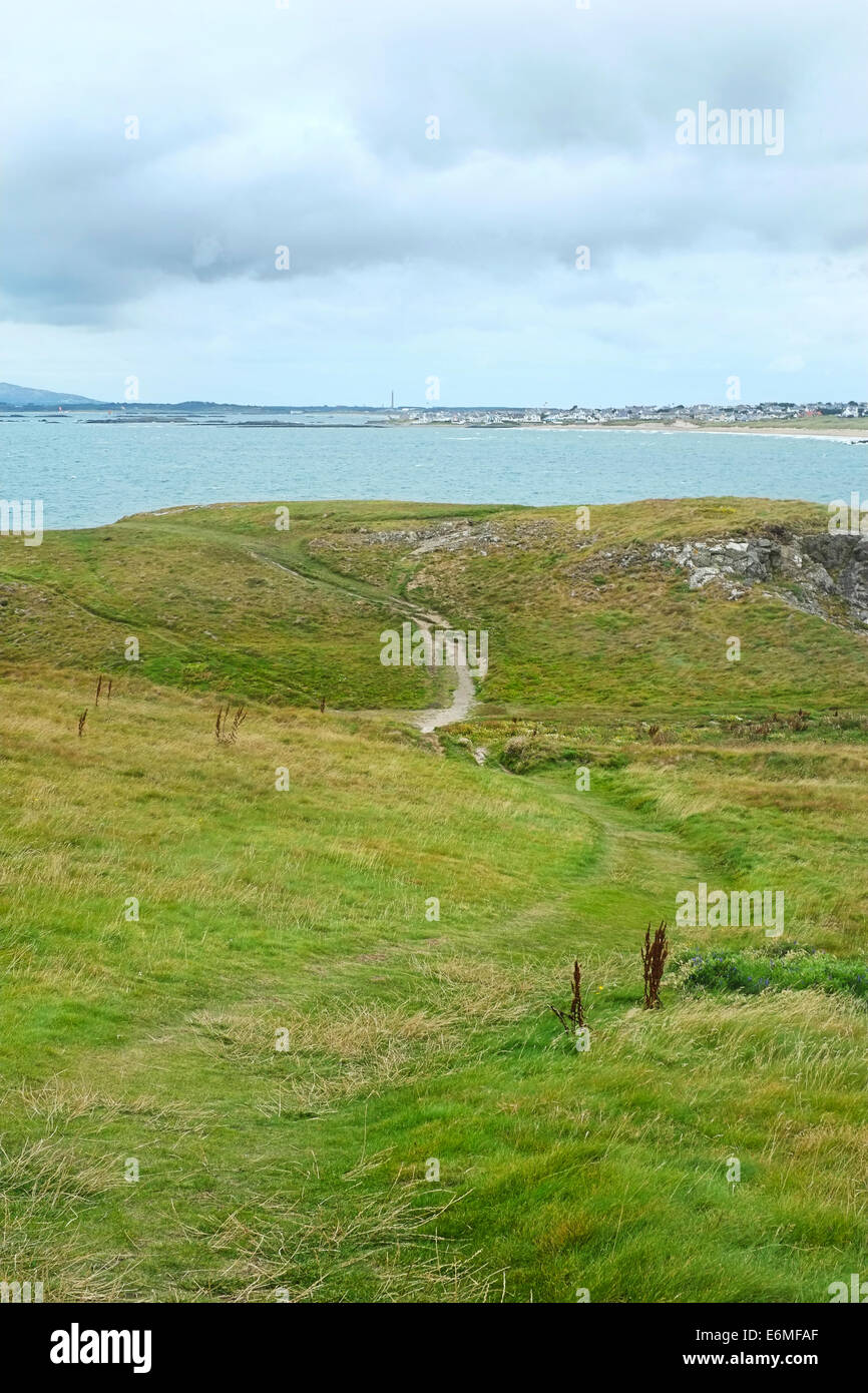 Spaziergang entlang der Küste von Burial Chamber, Anglesey, North Wales, Blick zurück in Richtung Rhosneigr und RAF Valley Stockfoto