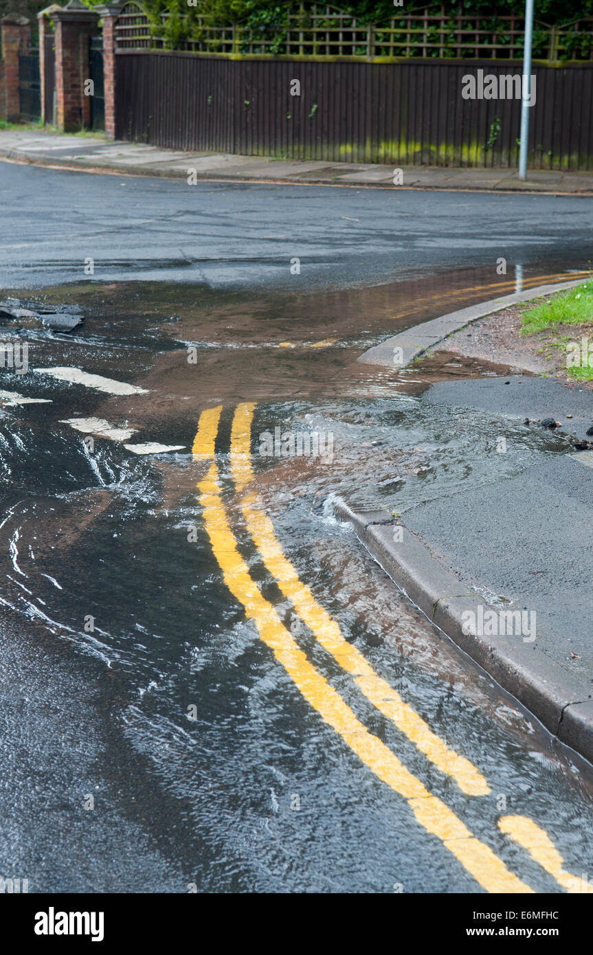 Wasser-Leck aus einen Wasserrohrbruch in der Straße Stockfoto