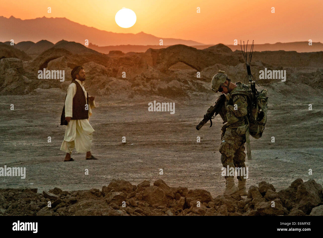 Ein Soldat der US Army auf Kampf Patrouille als ein afghanischer Mann geht vorbei an 18. August 2014 in Morghan Kachah, Provinz Kandahar, Afghanistan. Stockfoto