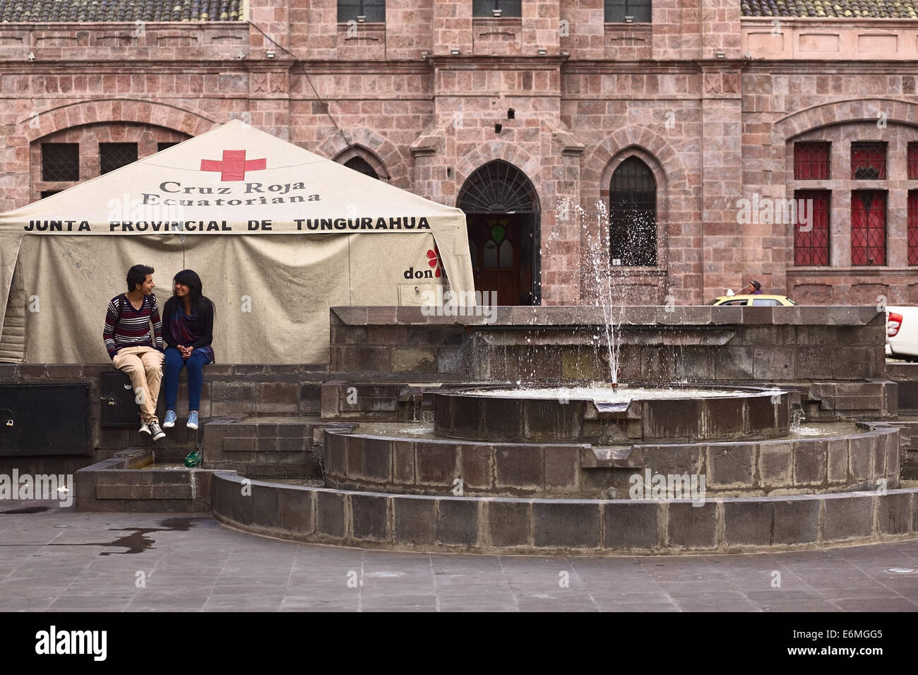Nicht identifizierte junge Menschen sitzen an einem Brunnen in Cevallos Park in Ambato, Ecuador Stockfoto