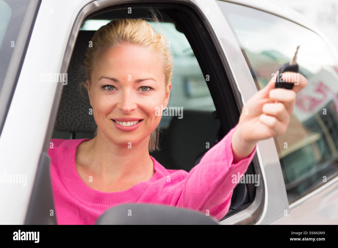 Kaukasische Dame zeigt einen Autoschlüssel. Stockfoto