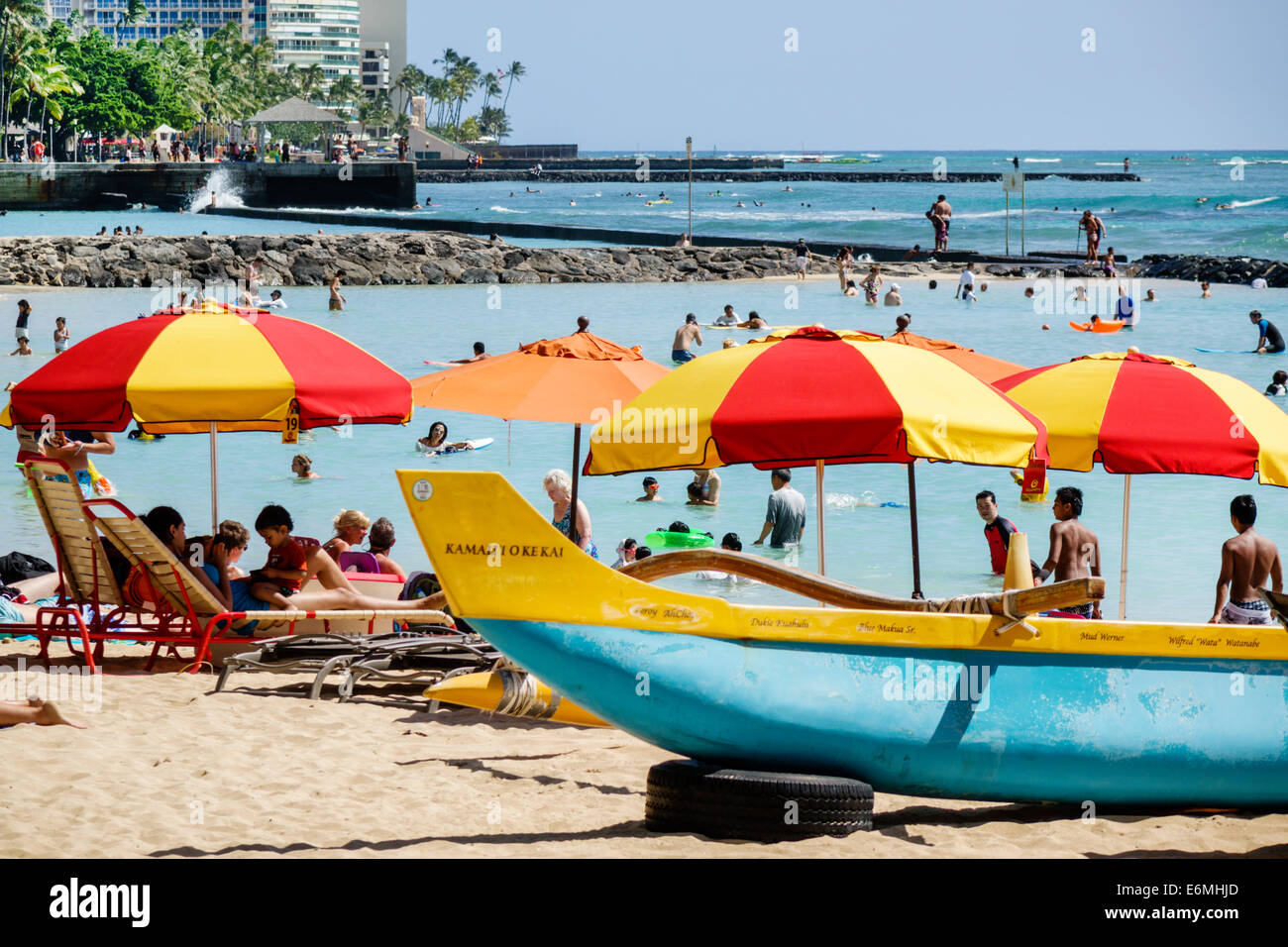 Honolulu Waikiki Beach Hawaii, Hawaiian, Oahu, Wasser im Pazifischen Ozean, Kuhio Beach Park, am Wasser, Sonnenanbeter, Schwimmer, Badegäste, Sand, Auslegerkanu, Regenschirme Stockfoto