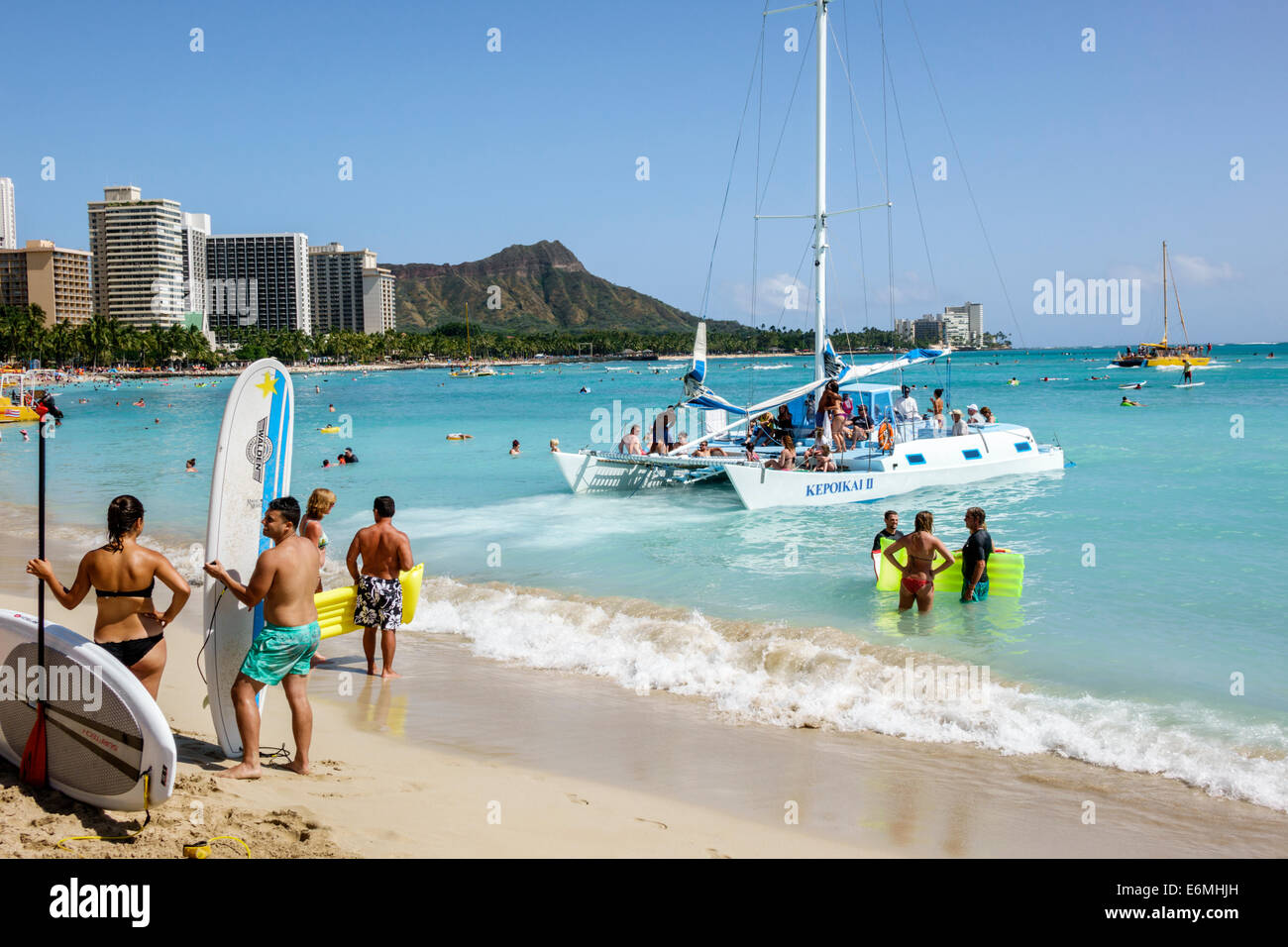 Honolulu Waikiki Beach Hawaii, Hawaiian, Oahu, Pazifischer Ozean, Waterfront, Sonnenanbeter, Surfbrett, Kepoikai II Katamaran, Boot, Diamond Head Crater, ausgestorbene Volca Stockfoto