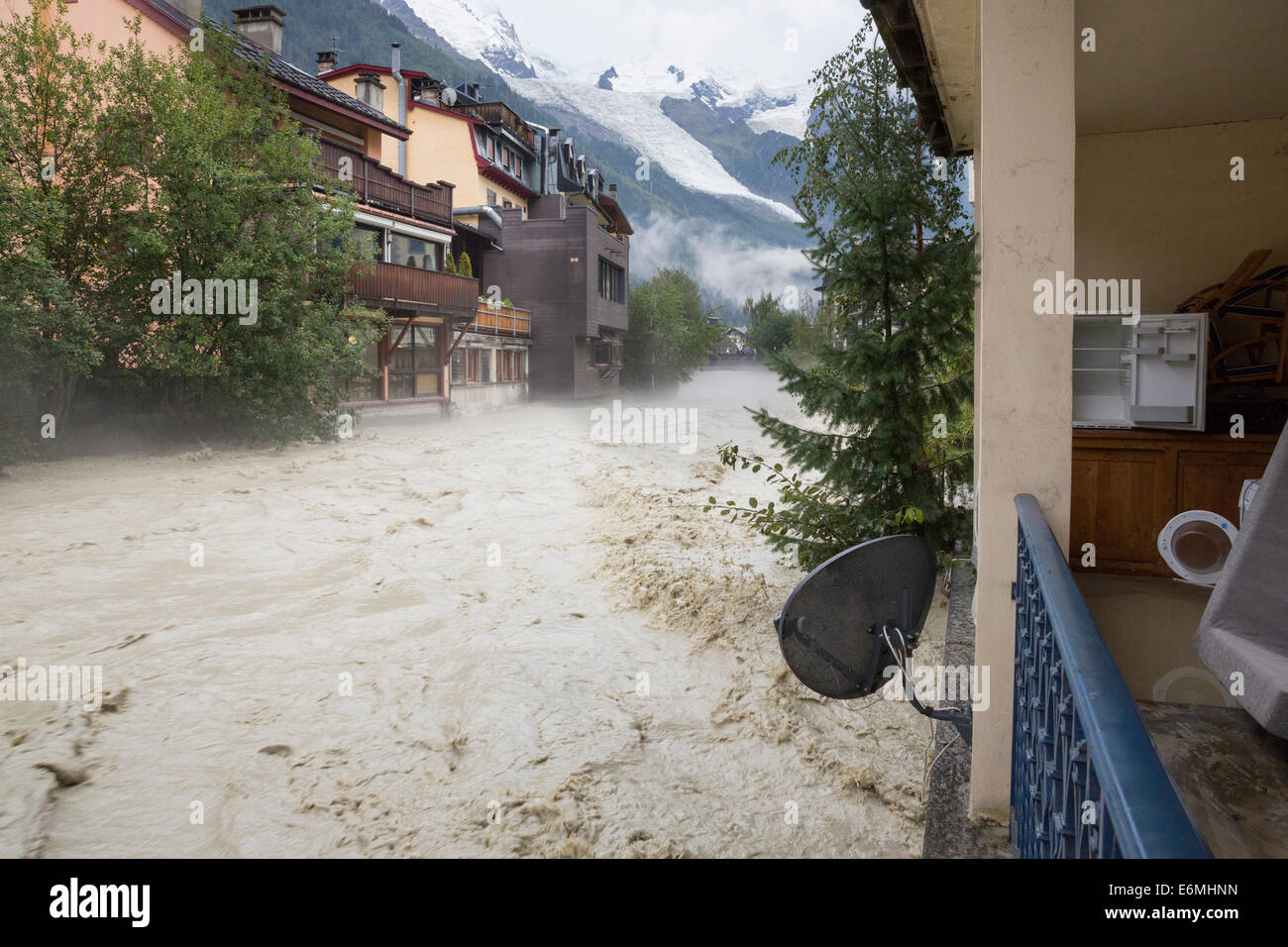 Chamonix Mont Blanc, Frankreich. 26. August 2014. Einige Sachen von einer überfluteten Wohnung sind auf dem Balkon eines Wohnsitzes auf Rue Docteur Paccard in Chamonix, als der Fluss tobt daneben, mit Blick auf Mont Blanc. Die Arve Fluss bedroht die französischen Alpen Chamonix Mont Blanc mit einem plötzlichen Anstieg um 14h nach einem Tag mit starkem Regen während einer der regenreichsten Sommer in den letzten 100 Jahren in den Alpen. Bildnachweis: Genyphyr Novak/Alamy Live-Nachrichten Stockfoto