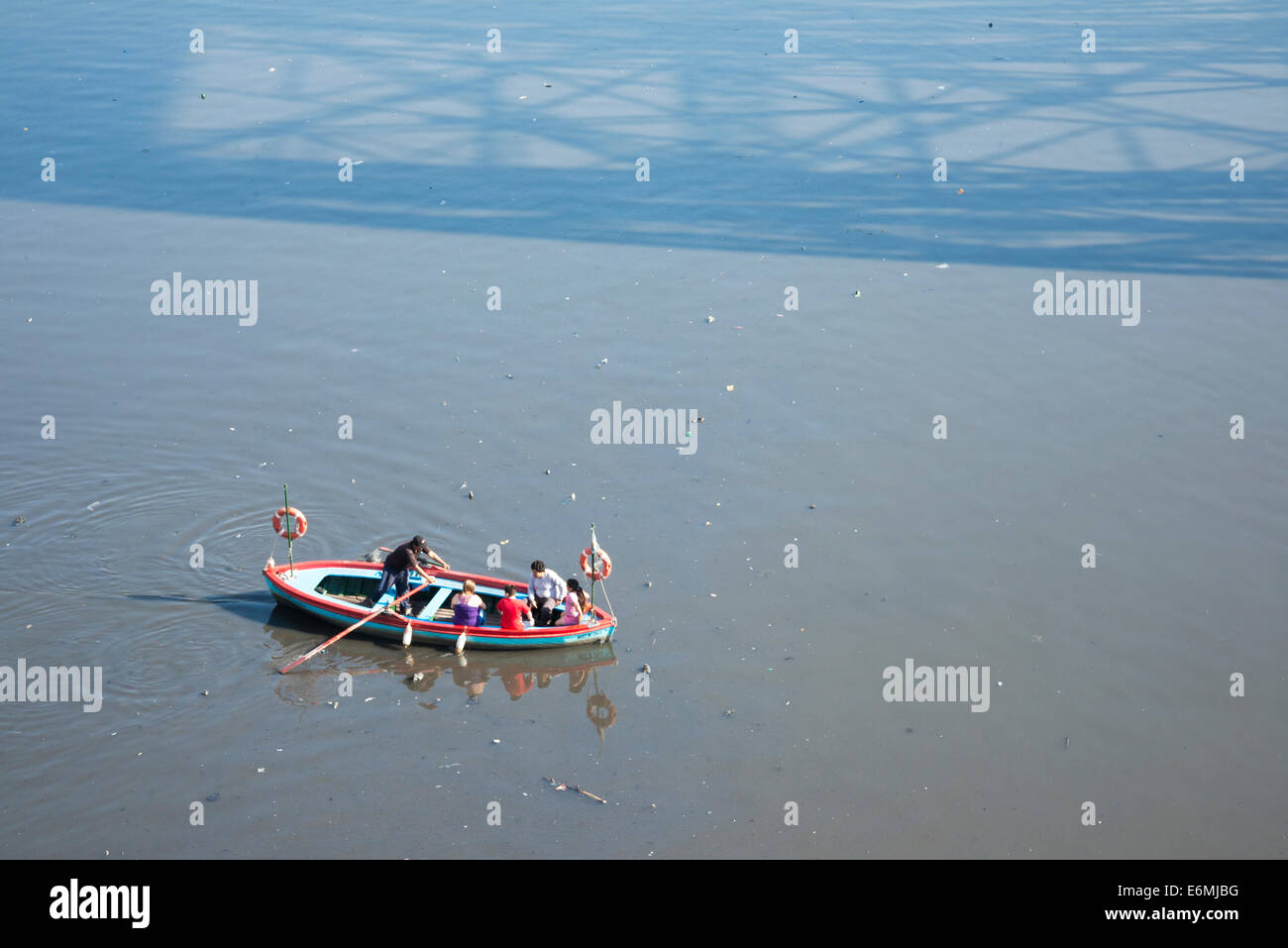 Ein Ruderer Kreuzung Volk über den Fluss Riachuelo in einem hölzernen Ruderboot in La Boca-Viertel von Buenos Aires, Argentinien. Stockfoto