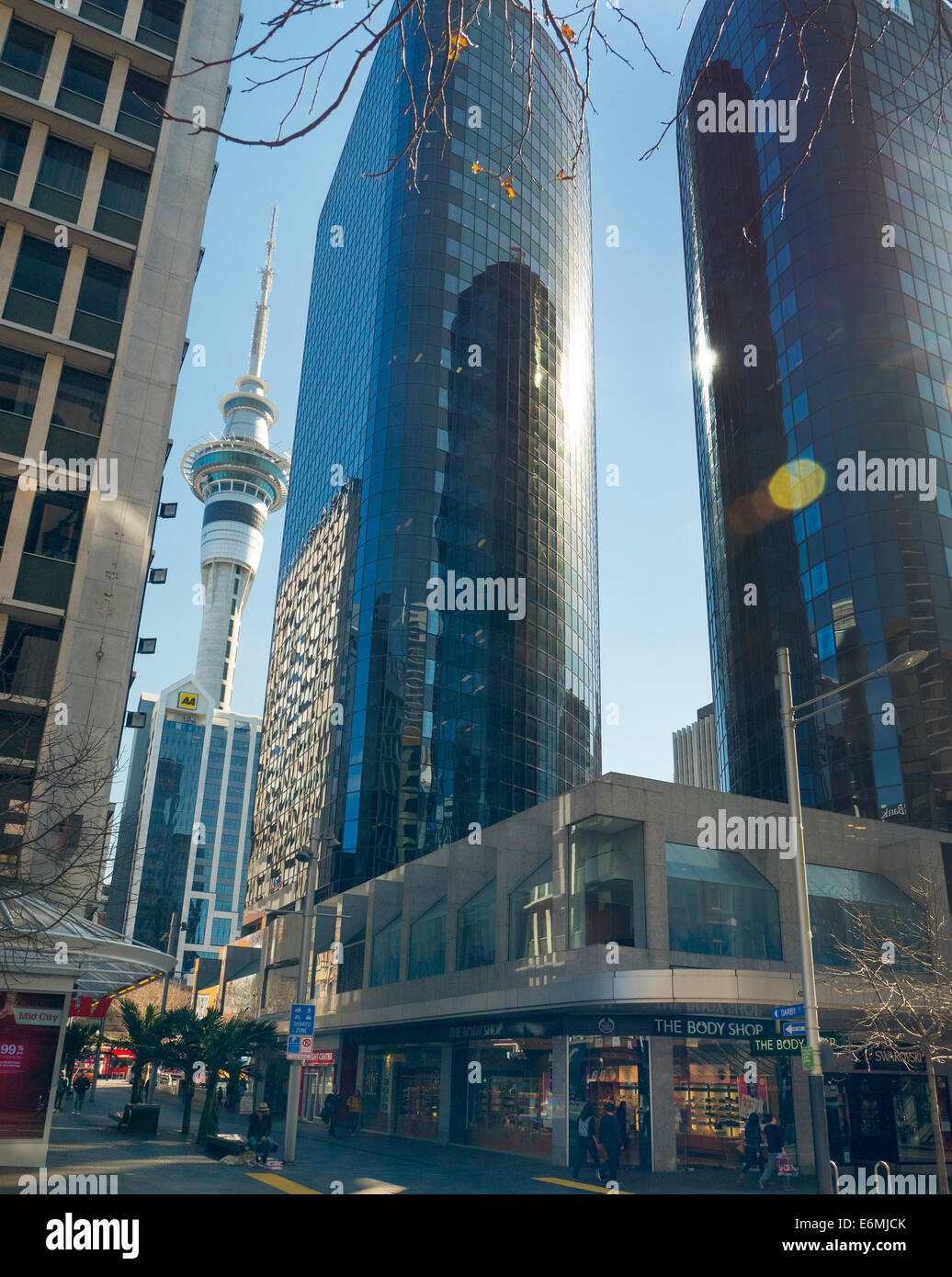 Glas verkleidet Bürogebäude auf der Queen Street Auckland City mit Skytower hinten Stockfoto