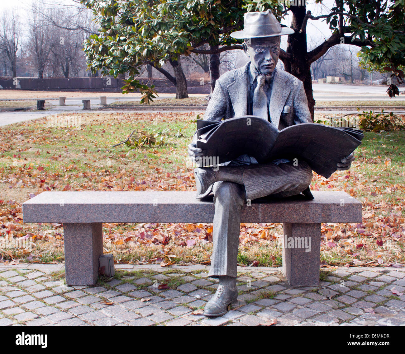 Man liest eine Zeitungsstatue in Tulsa, Oklahoma, ist ein skurriles Bronze-Kunstwerk, das einen ruhigen Alltagsmoment in der öffentlichen Kunst einfängt. Stockfoto