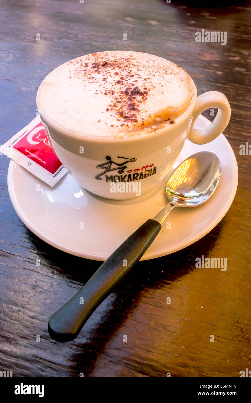 Cappuccino mit einem Zuckerbeutel und einem Löffel, Italien Stockfoto