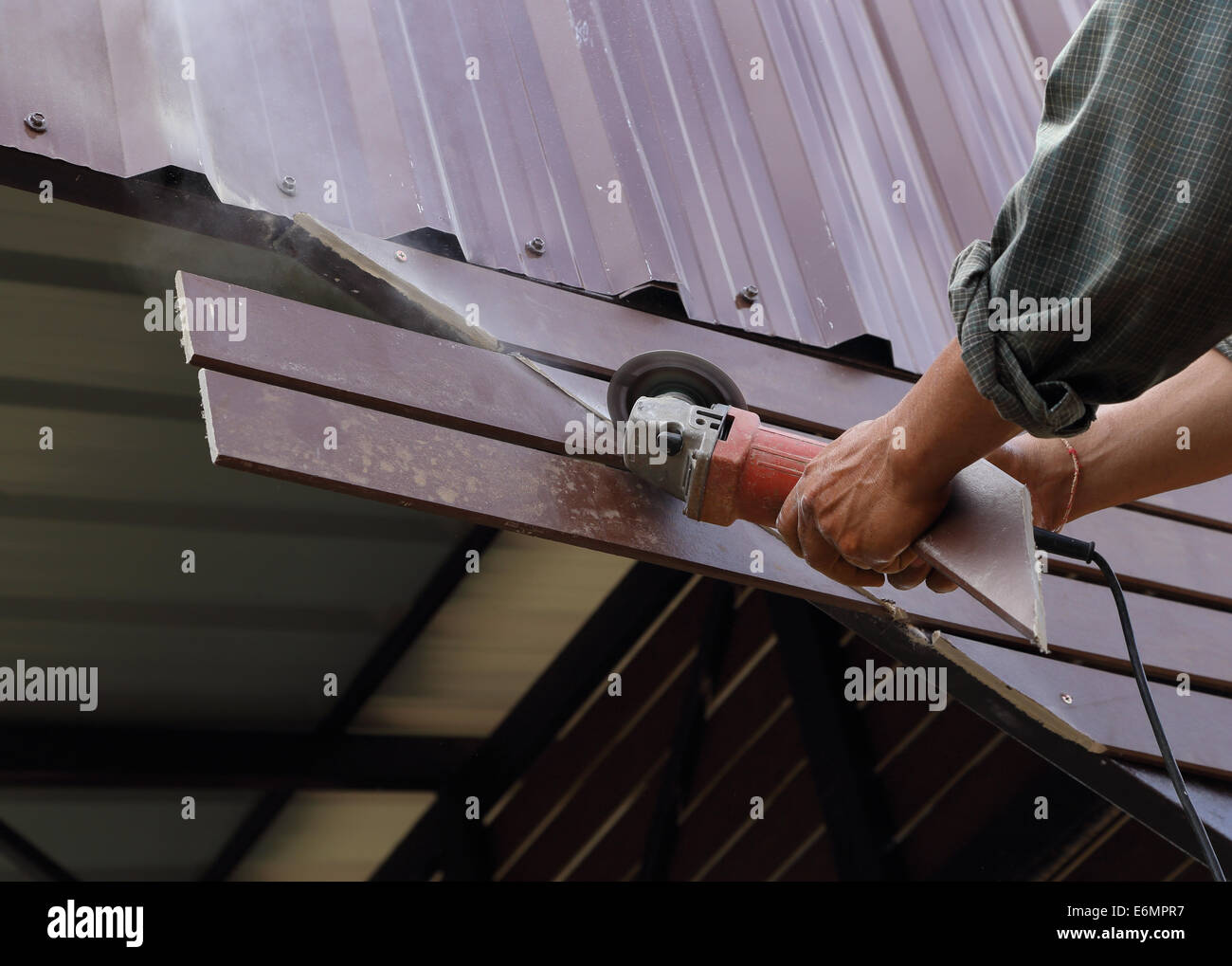 Arbeitnehmer nutzen kleine Schleifwerkzeug für das Schneiden von Holz Bau Stockfoto