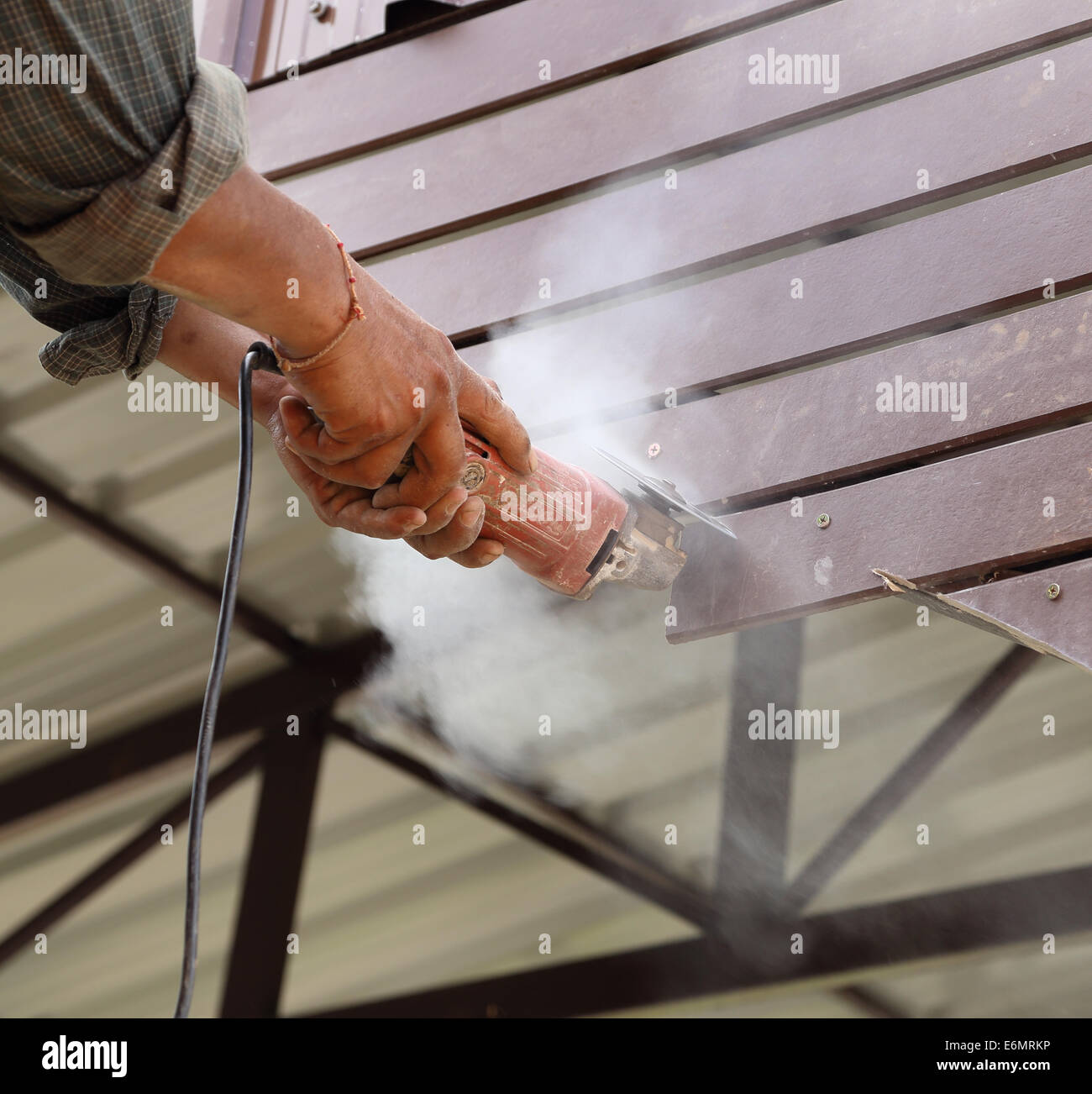 Arbeitnehmer nutzen kleine Schleifwerkzeug für das Schneiden von Holz Bau Stockfoto