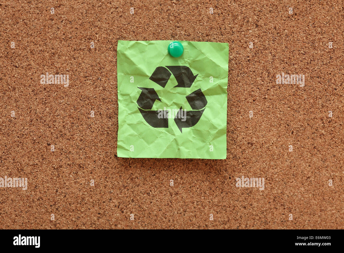 Zerknitterte Klebstoff Hinweis mit grünen Recycling-Symbol auf Pinnwand (Bulletin Board). Stockfoto
