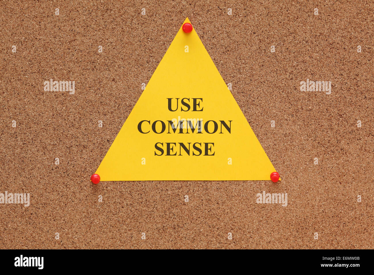 Dreieckigen Papier-Schuldbrief mit den Worten "gesunden Menschenverstand auf Pinnwand (Bulletin Board) verwenden". Stockfoto