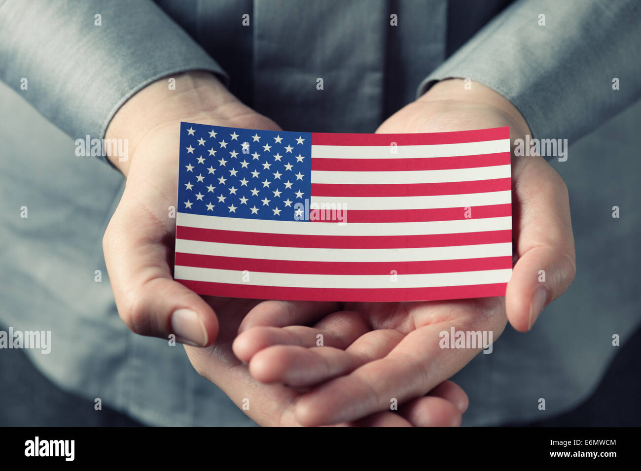 Pflegenden Händen halten die amerikanische Flagge. Liebe für das Land. Stockfoto