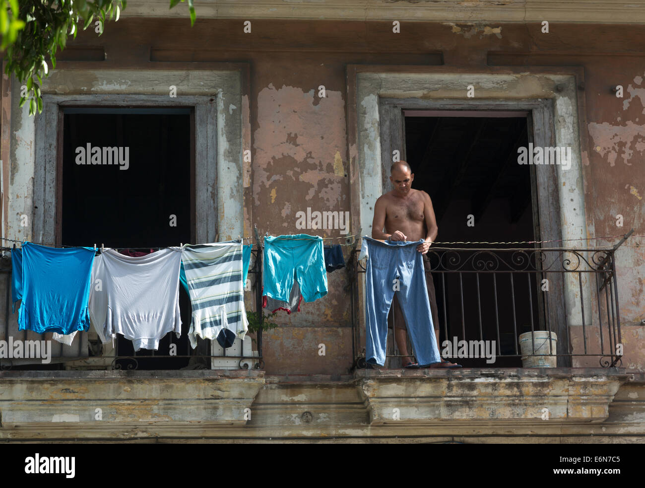 Mann mit Wäsche auf Balkon, Zentral-Havanna, Kuba Stockfoto