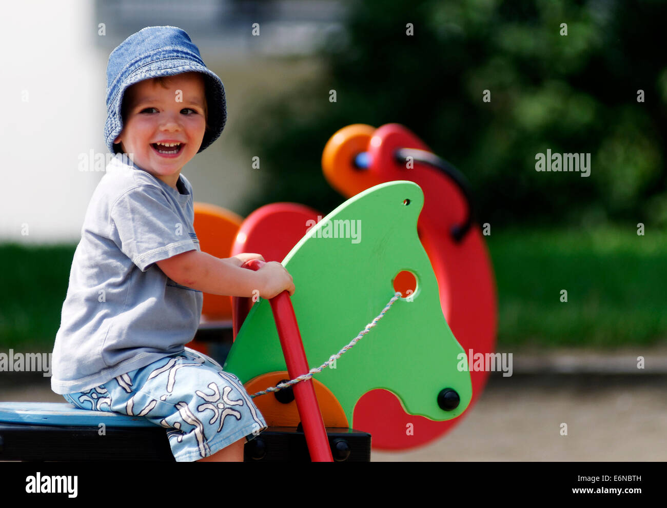 Ein lächelndes glückliche junge Junge spielt auf einem Spielplatz Stockfoto