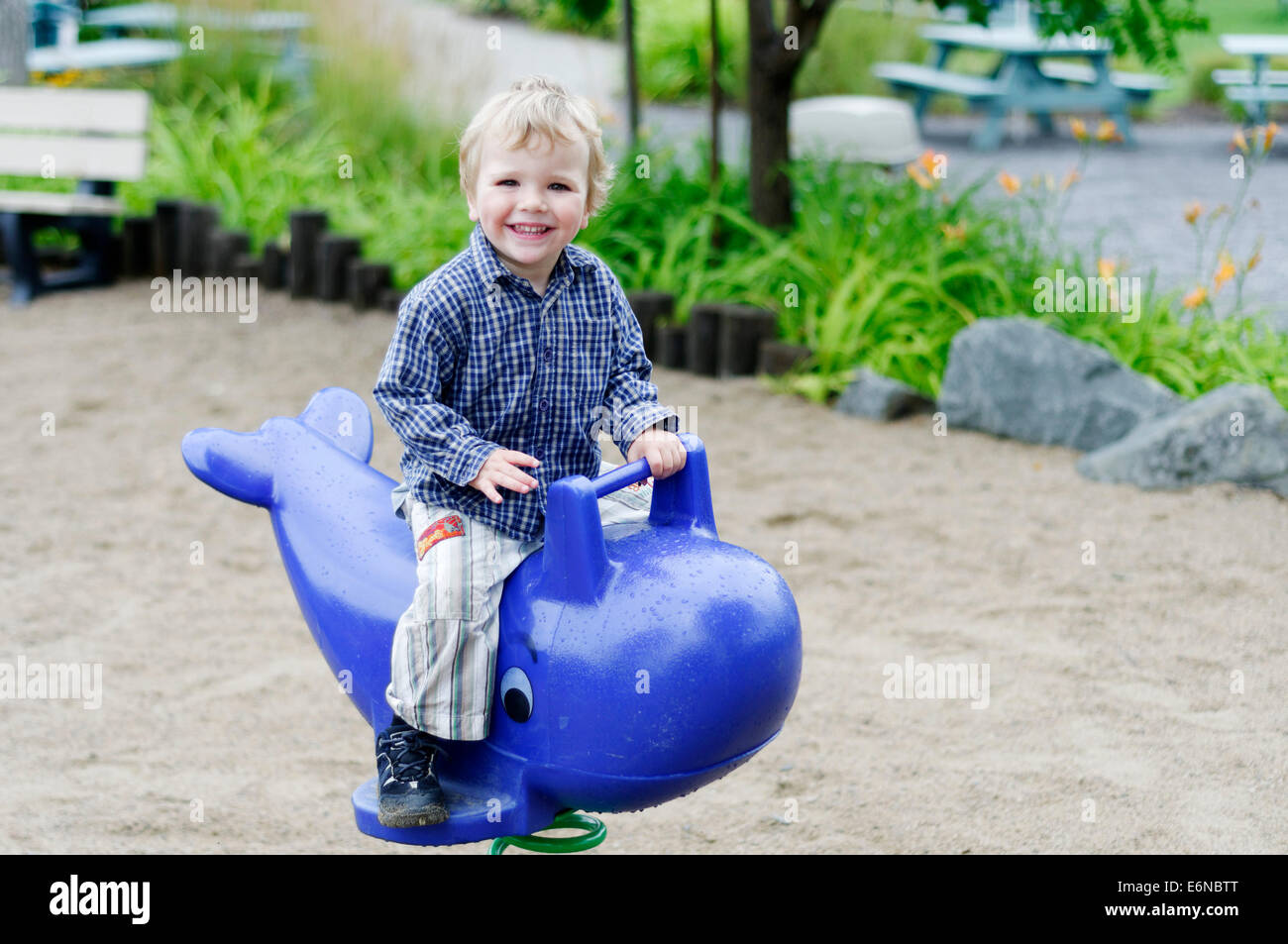Ein lächelndes glückliche junge Junge spielt auf einem Spielplatz Stockfoto