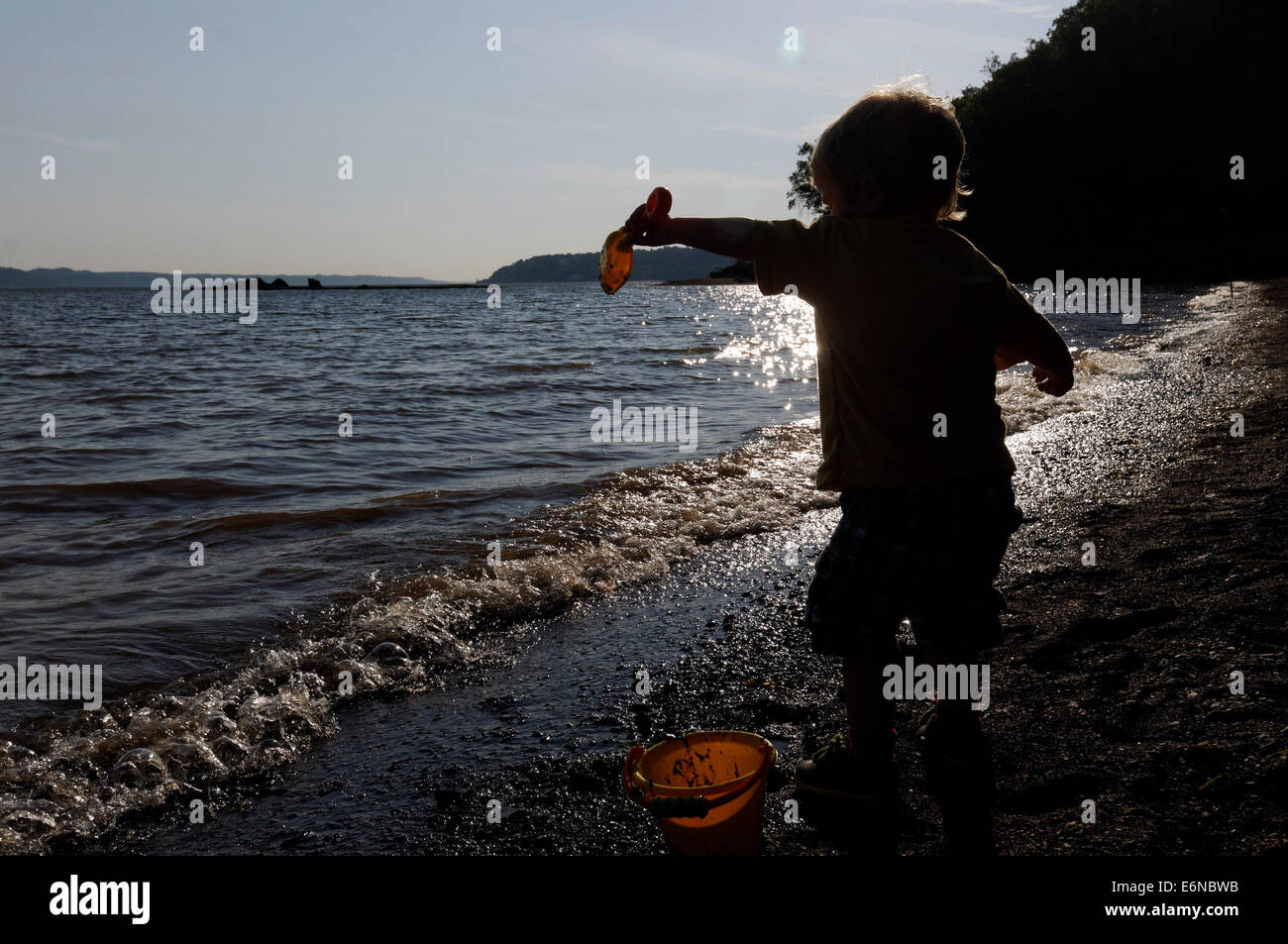 Ein kleiner Junge spielt mit einem Eimer und Schaufel auf der Strand Plage Jacques Cartier Quebec an der Küste von St. Lawrence Stockfoto