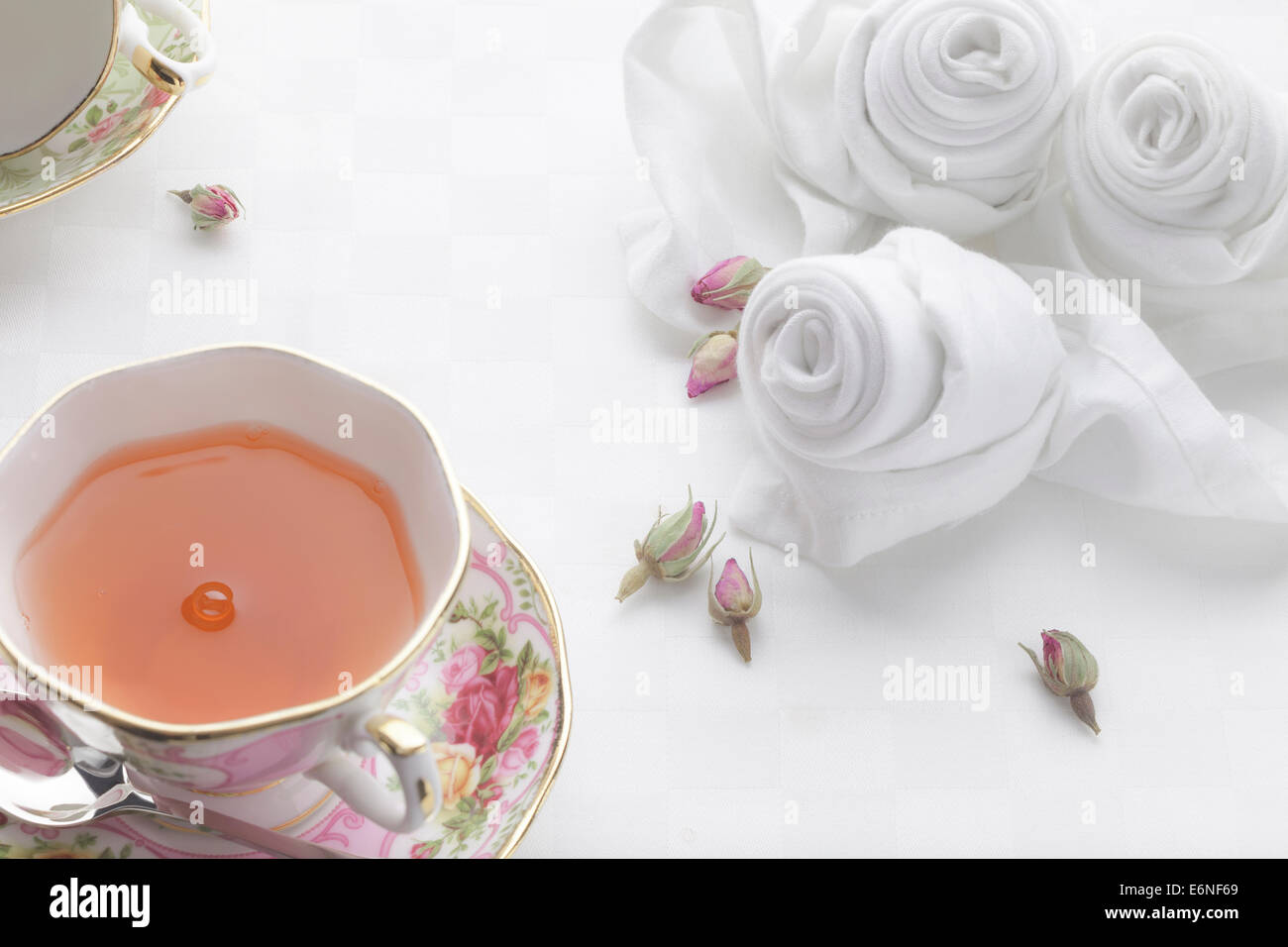 Rose Tee mit feinem Porzellan verziert mit rosa gefaltete Servietten Stockfoto