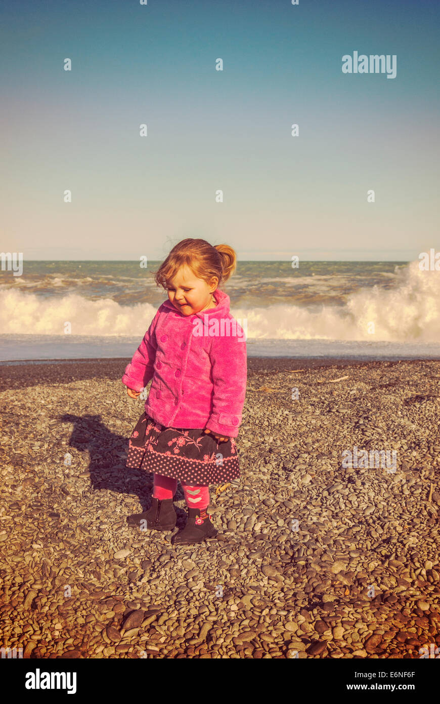 Kleines Mädchen 2 Jahre alt, alle verkleidet in ein rosa Fell Jacke an  einem Winter-Strand mit Instagram-Filter Stockfotografie - Alamy