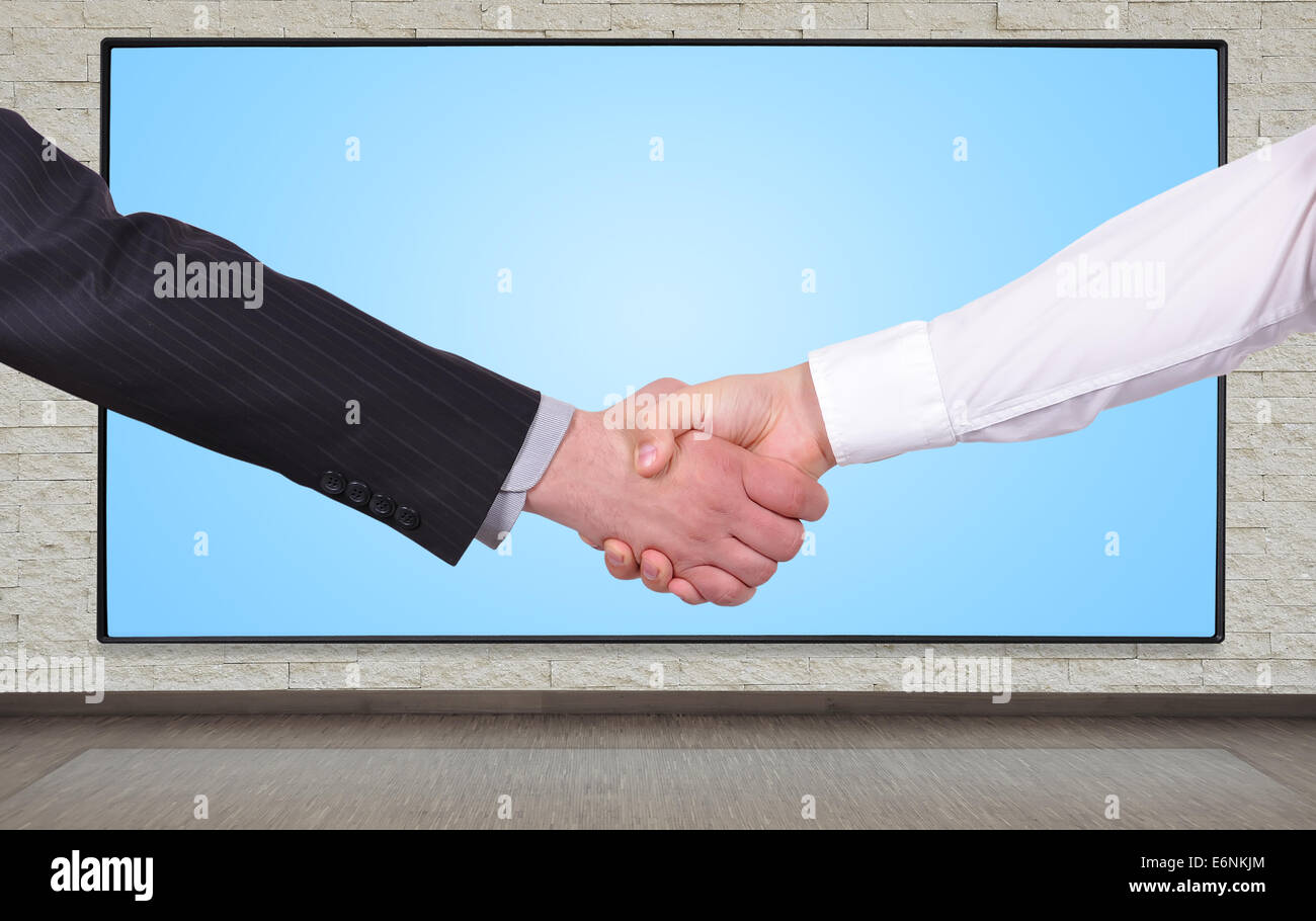 Handschlag auf einem großen Plasma-Panel-Hintergrund Stockfoto
