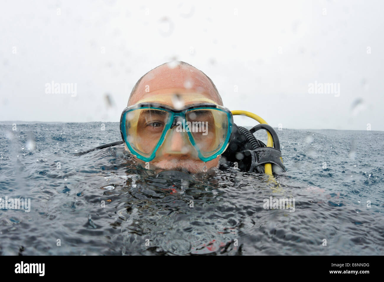 Scuba Diver Porträt im Regen an der Wasseroberfläche Stockfoto