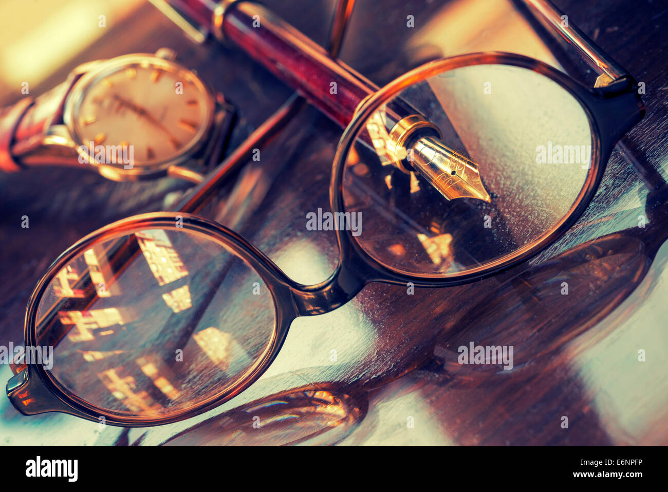 Stift, Gläser und Armbanduhr auf einem Tisch glänzend Stockfoto