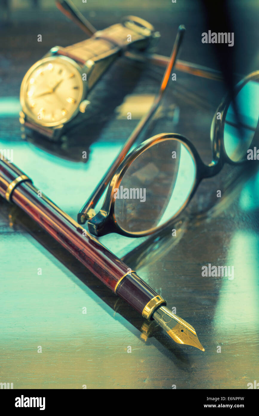 Stift, Gläser und Armbanduhr auf einem Tisch glänzend Stockfoto