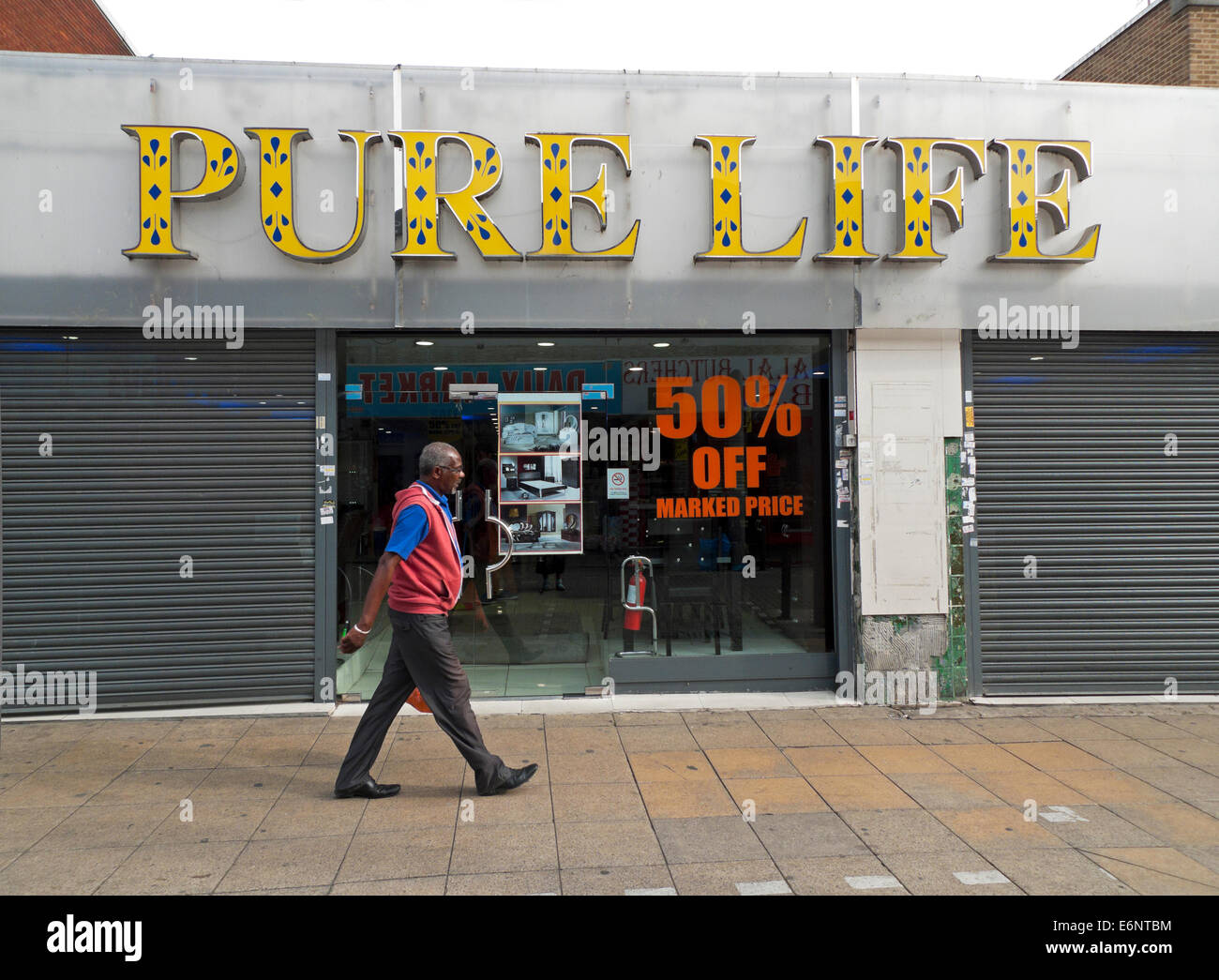 Mann zu Fuß vorbei an Pure Life Store in Walthamstow High Street, Borough of Waltham Forest, London UK KATHY DEWITT Stockfoto