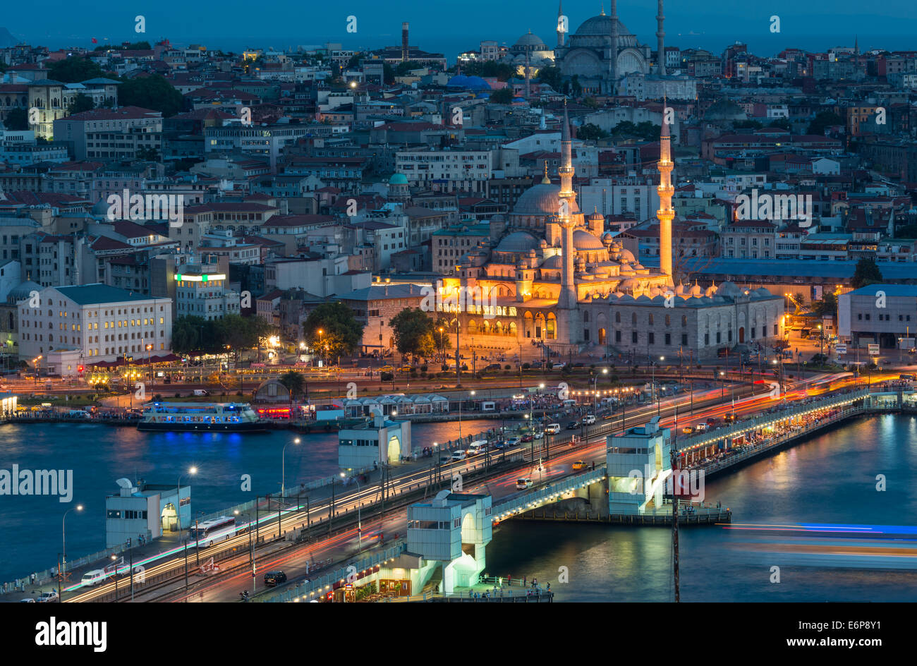 Yeni Cami (neue Moschee) beleuchtet in der Nacht, mit Galata-Brücke im Vordergrund. Stockfoto