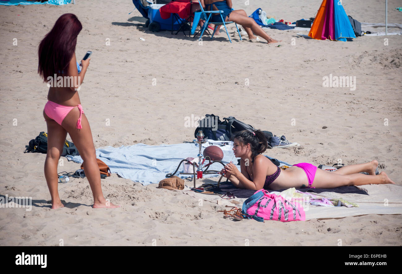 Junge Frauen rauchen ihre Wasserpfeife am Strand von Coney Island in  Brooklyn in New York Stockfotografie - Alamy