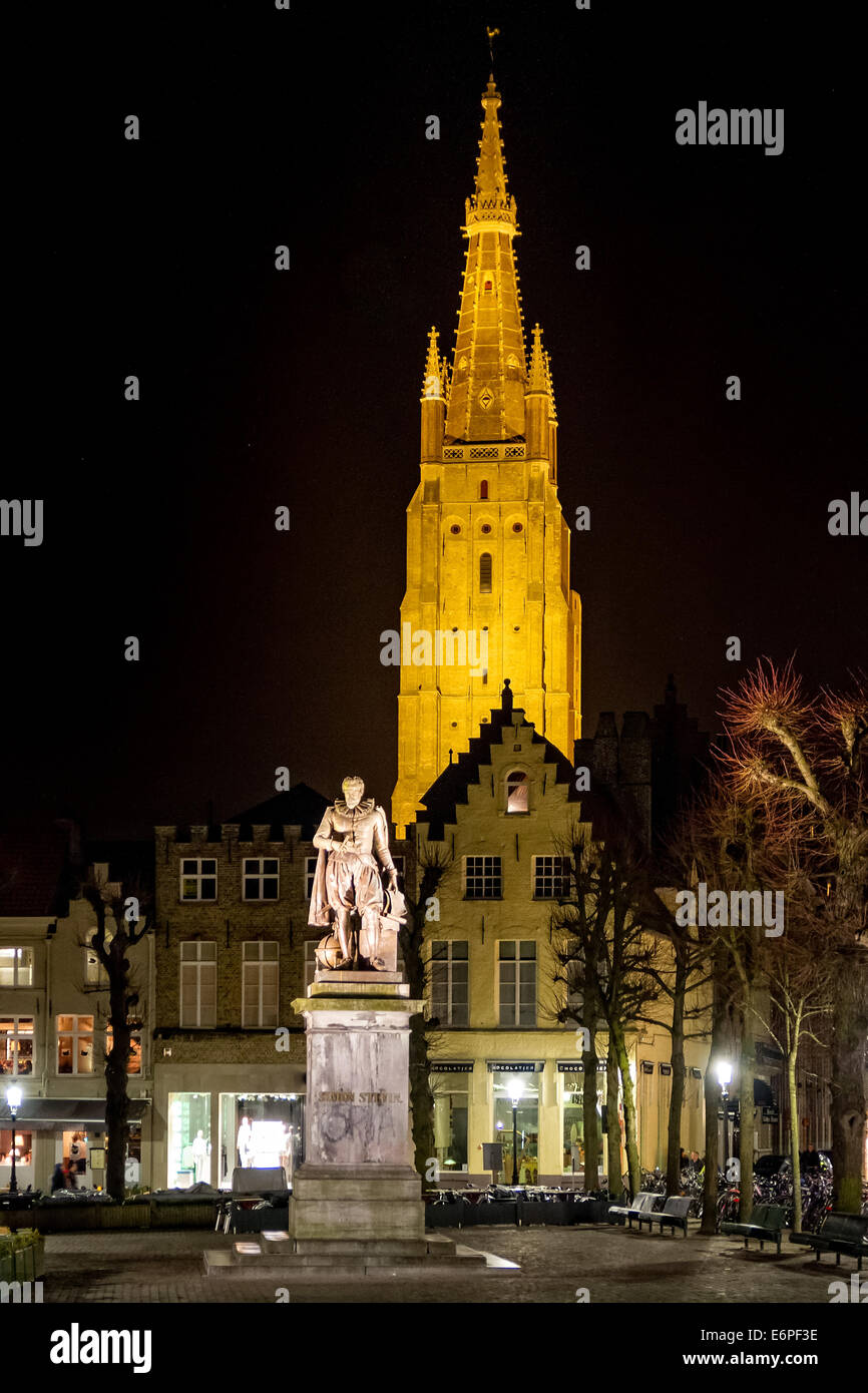 Nachtaufnahme mit der Statue der Mathematiker Simon Stevin und Brügger Kirche unserer lieben Frau im Hintergrund Stockfoto