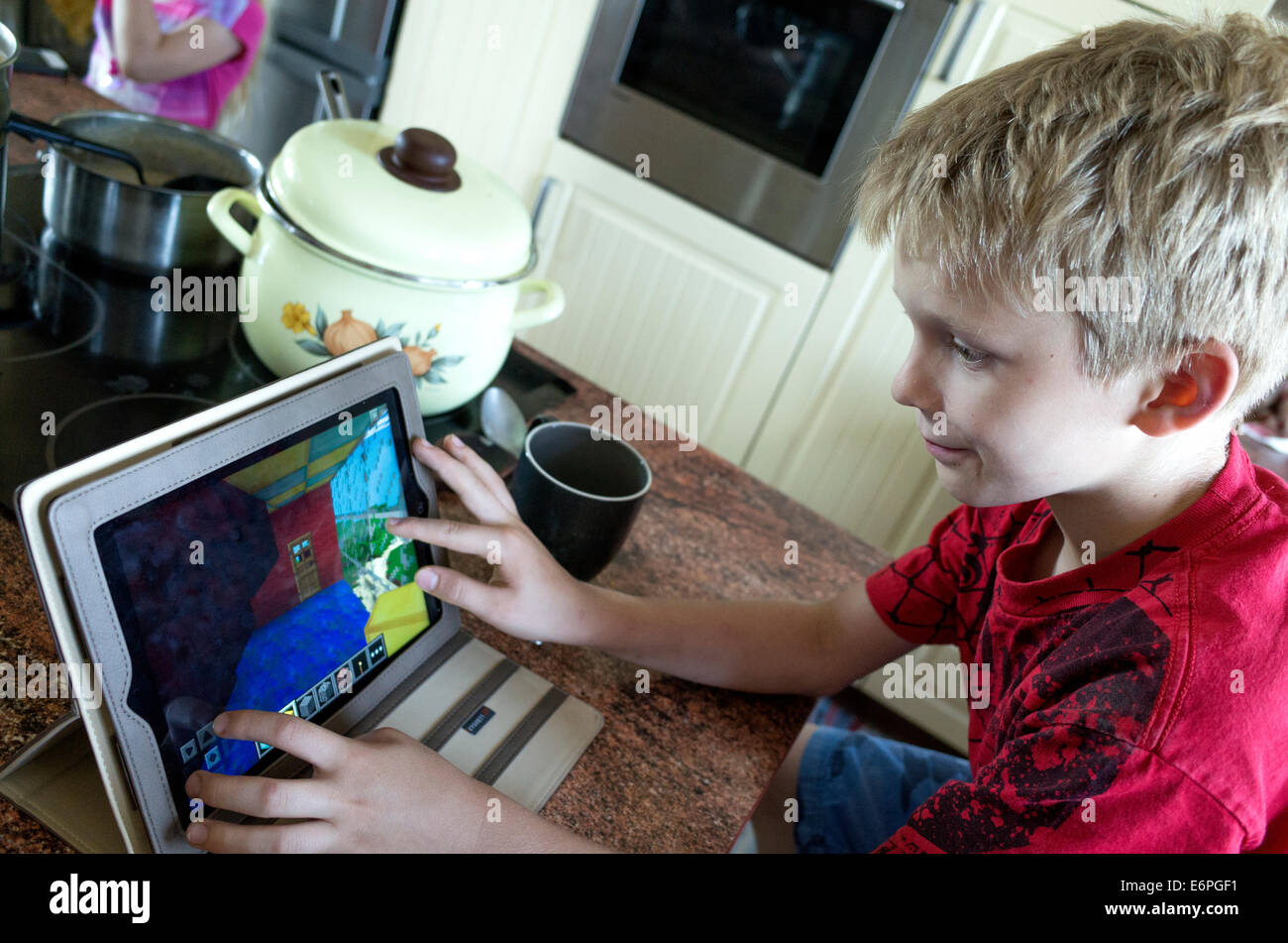 Polnischen jungen Alter von 10 Jahren entwerfen Häuser auf seinem Tablettcomputer in der Küche. Zawady Polen Stockfoto