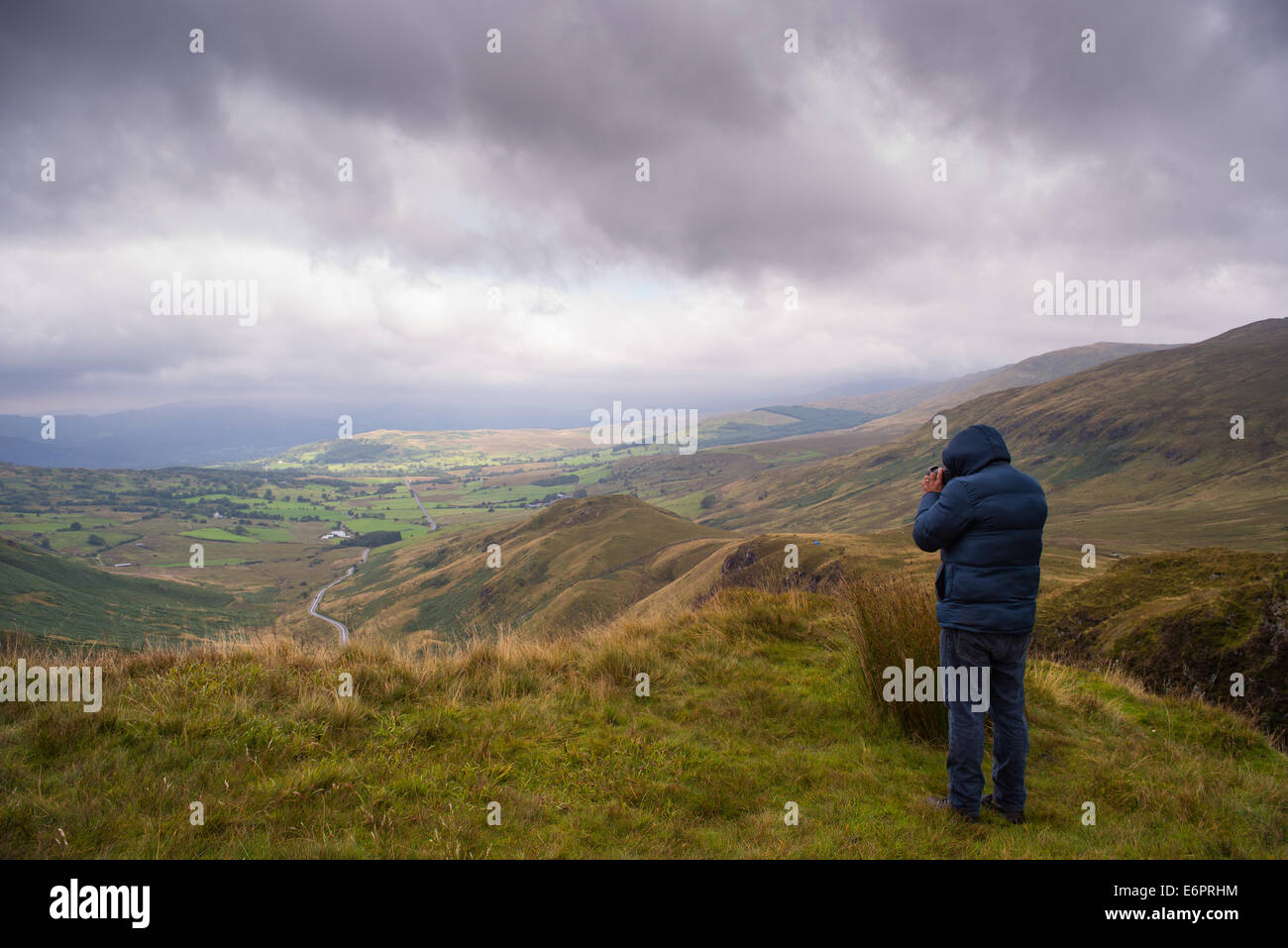 Mann mit Landschaft fotografieren bei stürmischem Wetter im walisischen Bergen Stockfoto