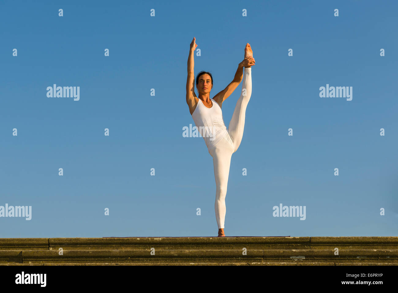 Junge Frau praktizieren Hatha Yoga im Freien, hob zeigen die Pose Anjaneyasana, die Hand um die Pose zu Fuß Stockfoto