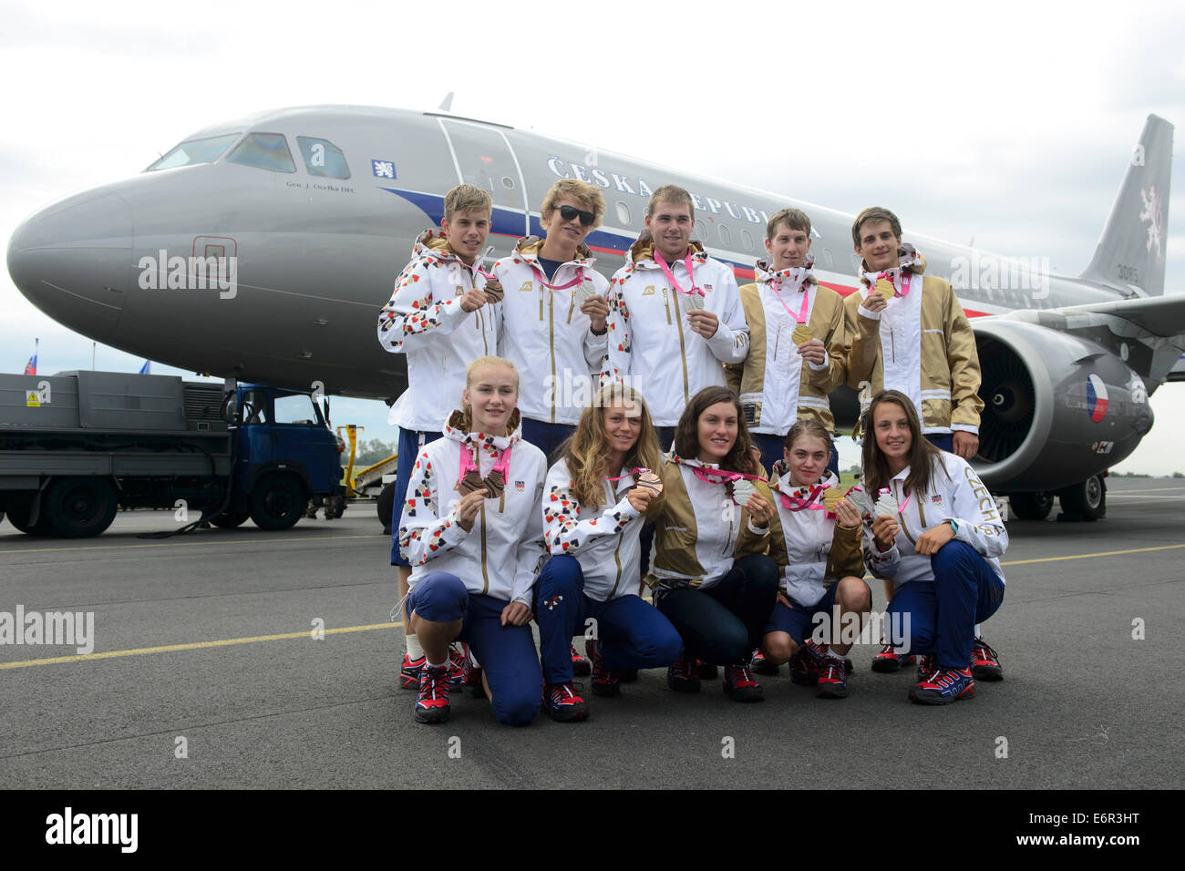 Mitglieder des tschechischen Teams posieren mit Medaillen von den Olympischen Spielen der Jugend in China nach ihrer Ankunft am Flughafen in Prag, Tschechien am 29. August 2014. Sitzend von links: Michaela Hruba, Bronzemedaille im Hochsprung und in Staffel 8 x 100 Meter, Amalie Hilgertova, Bronze im Slalom Wasser, Barbora Prudkova, Radfahren, Nikola Noskova Gold in der mixed-Staffel, Martina Satkova, Silber Wasser Slalom. Obere Reihe von links: Krystof Hajek, Bronze Medaille Geschwindigkeit Kanu, Miroslav Jech und Lukas Helesic, Silber paar im Rudern, Jan Rajchart und Roman Lehky, golden im Radsport mixed-Staffel. (CTK Foto/Michal Kam Stockfoto