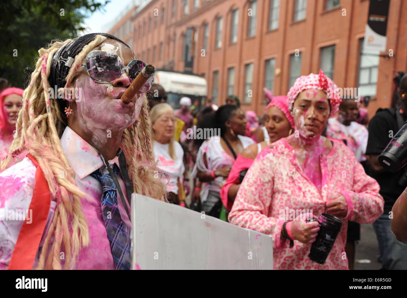 Frauen in Nottinghill Carnival am Familientag, raucht eine Zigarre Stockfoto