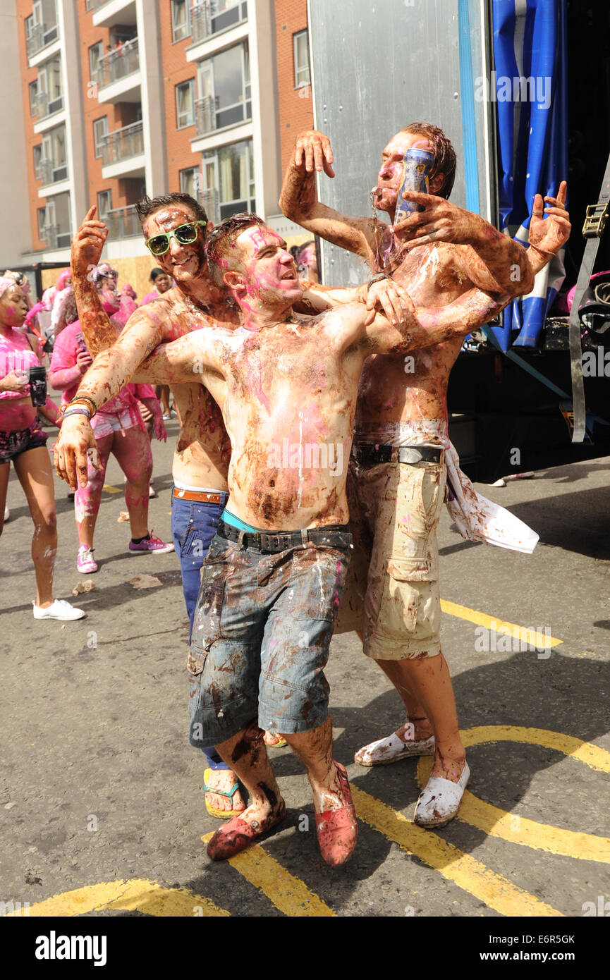 3 junge weiße Männer, die Spaß am Notting Hill Carnival am Familientag in Farbe bedeckt Stockfoto