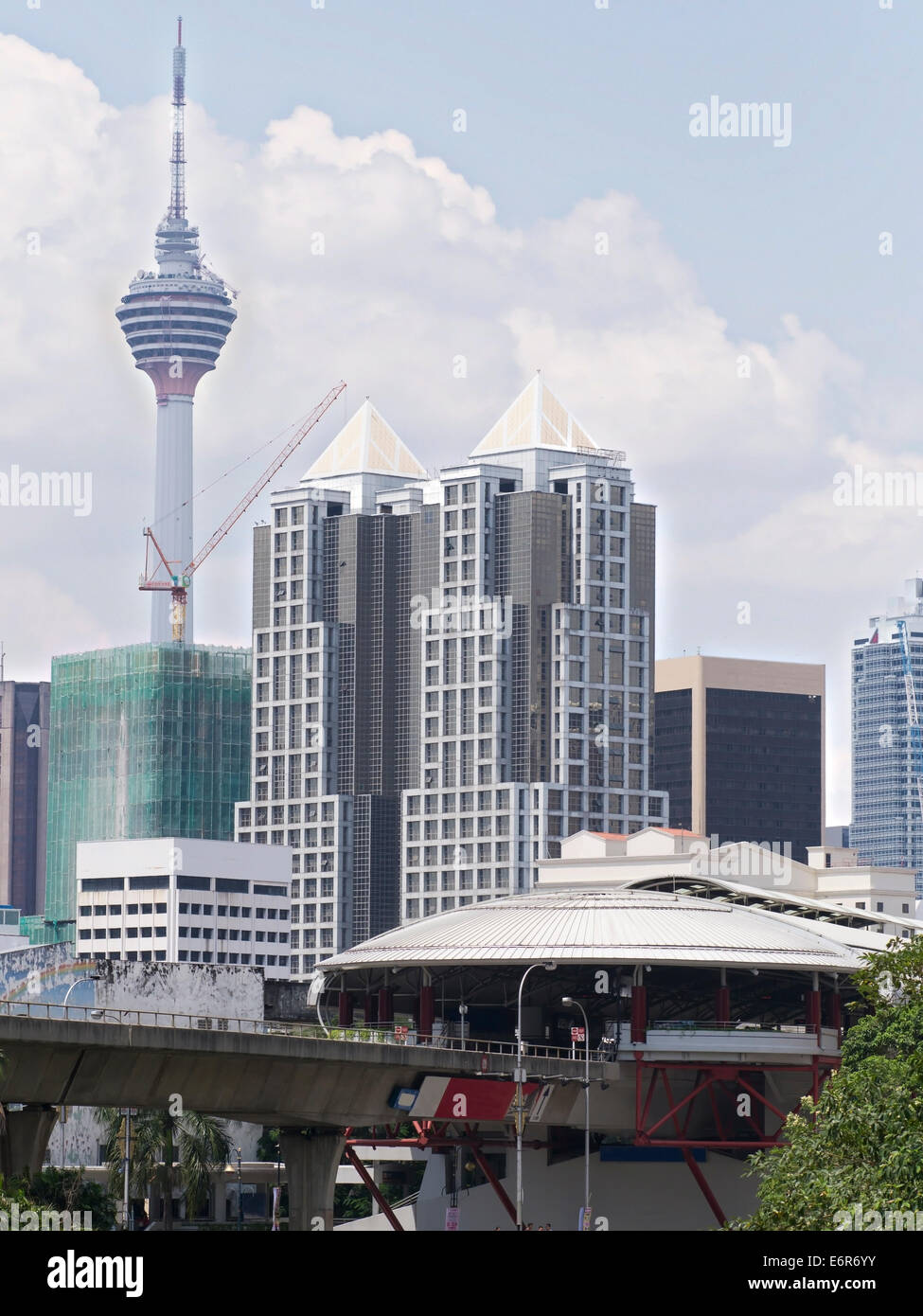 Skyline von Kuala Lumpur mit einer Stadtbahn-Station im Vordergrund und dort Menara Kuala Lumpur Tower im Hintergrund. Stockfoto