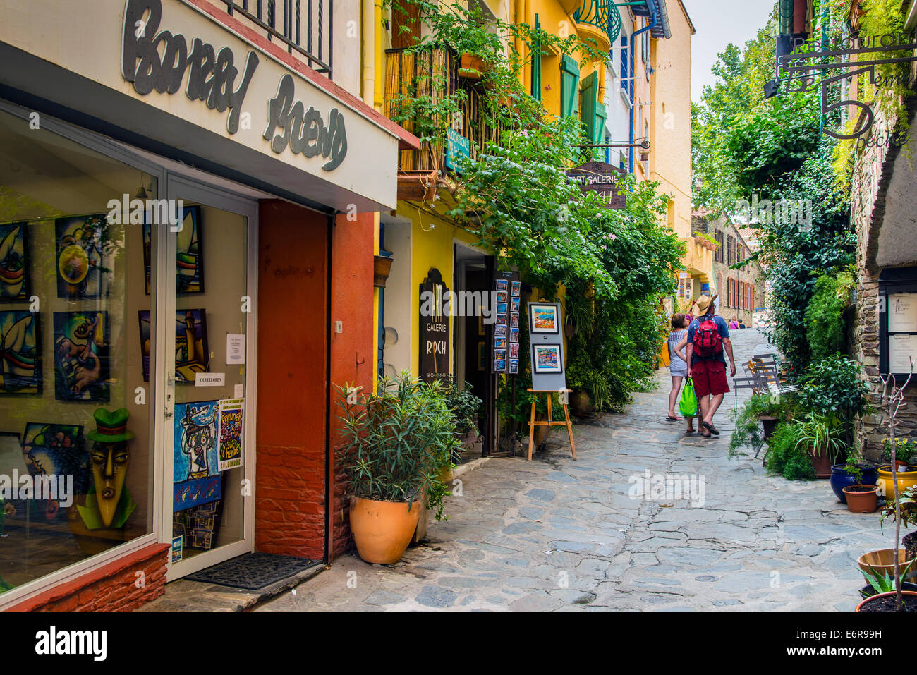 Gepflasterte Straße in der Altstadt mit Touristen und Kunstgalerien, Collioure, Languedoc-Roussillon, Frankreich Stockfoto
