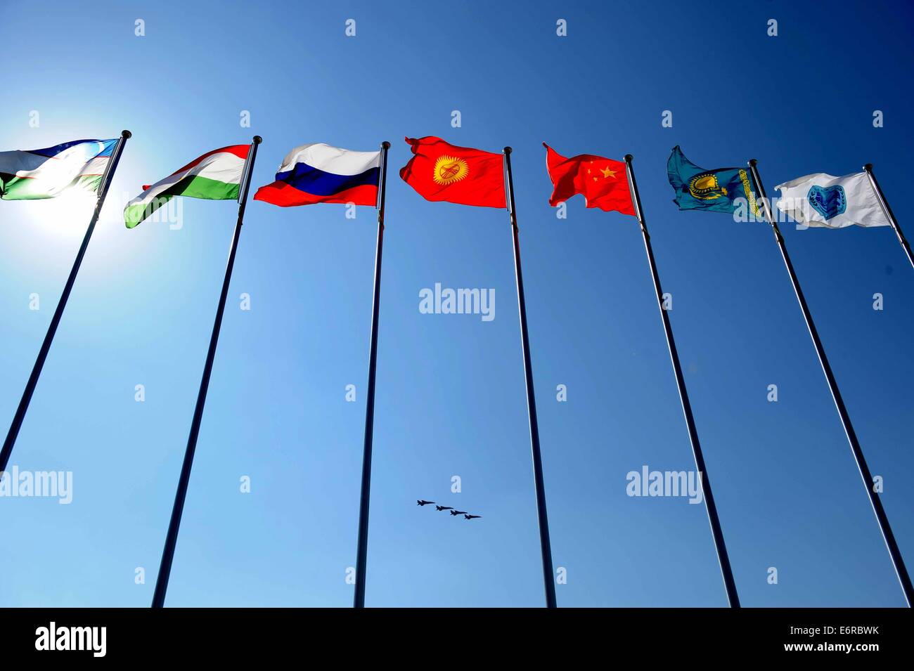 Zhurihe, Innere Mongolei, China. 29. August 2014. Flugzeuge fliegen über Flaggen der Shanghai Cooperation Organization (SCO) Mitgliedsländer bei der Abschlussfeier der Friedensmission - 2014 militärische in Zhurihe, Innere Mongolei, Nordchina, 29. August 2014 bohren. Der Bohrer, mit mehr als 7.000 Mitarbeiter aus China, Russland, Kasachstan, Kirgisistan und Tadschikistan und erwartet, dass multilaterale Entscheidungsfindung zu verbessern, gemeinsame Anti-Terror-Bemühungen zu schärfen und verbessern Austausch nachrichtendienstlicher Erkenntnisse um Frieden und Stabilität zu gewährleisten. Bildnachweis: Xinhua/Alamy Live-Nachrichten Stockfoto
