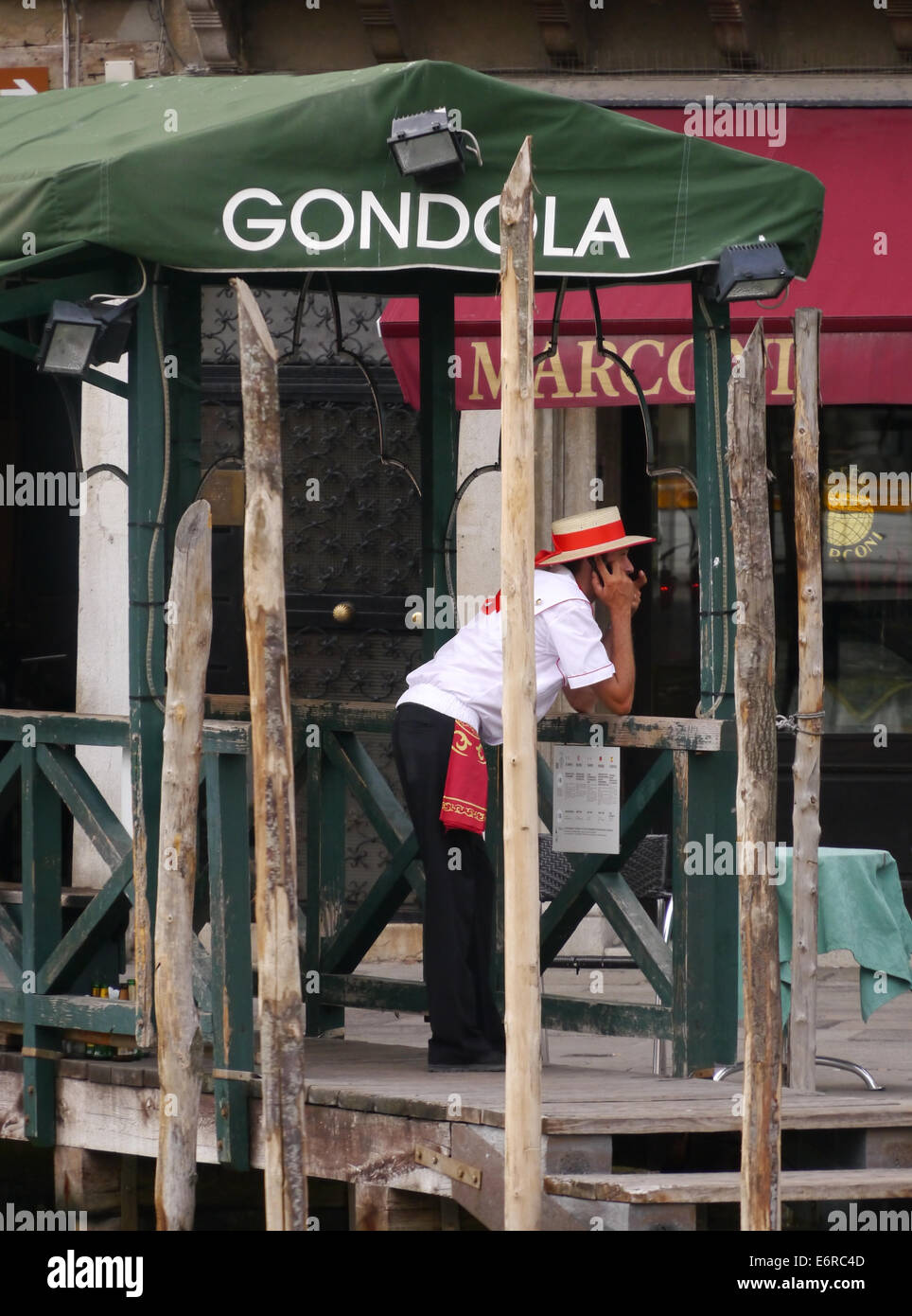 Ein Gondoliere in Venedig suchen gelangweilt stützte sich auf eine Bahn warten auf den nächsten Fahrgast Stockfoto