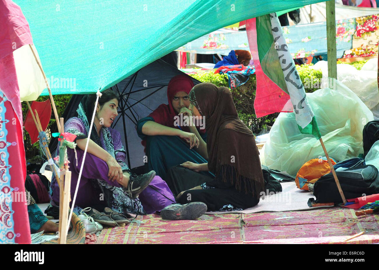 Frauen-Unterstützer von Tahir-Ul-Qadir anti-Regierung Protest vor Parliament House ruhen im Schatten während der sengenden Mittag von Islamabad auf Freitag, 29. August 2014. Stockfoto