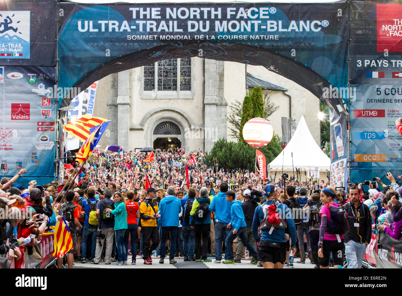 Chamonix Mont Blanc, Frankreich. 29. August 2014. Chamonix Mont Blanc, Frankreich. 29. August 2014. Läufer heben ihre Schlagstöcke in der Luft vor dem Start des Rennens Ultramarathon UTMB Trail. UTMB begann im Regen von Chamonix Mont Blanc, Frankreich um 17.30 Uhr am 29.08.2014. Das Rennen führt durch 3 Alpenländer (Frankreich, Schweiz und Italien), über viele hohe Pässe für insgesamt 163km laufen und 9600m Höhe Gewinn insgesamt während der Umrundung des Mont Blanc-Massivs. Das Rennen wird in Teilautonomie mit nur ein paar Haltestellen für Futter und Wasser durchgeführt. Es läuft für 2 Nächte Stockfoto