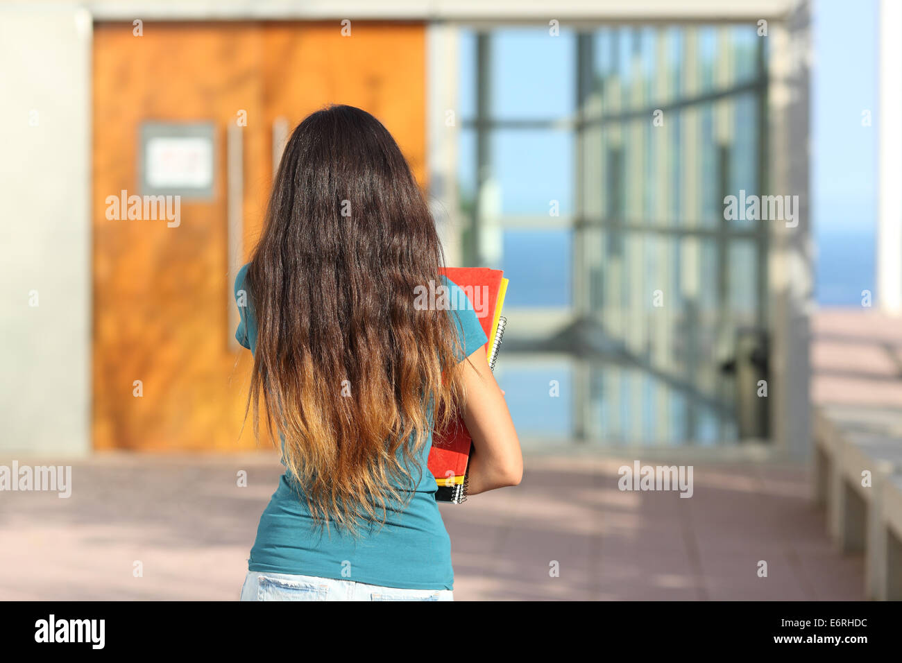 Rückansicht des Teen Girl zu Fuß in Richtung der Schule mit der Tür im Hintergrund Stockfoto