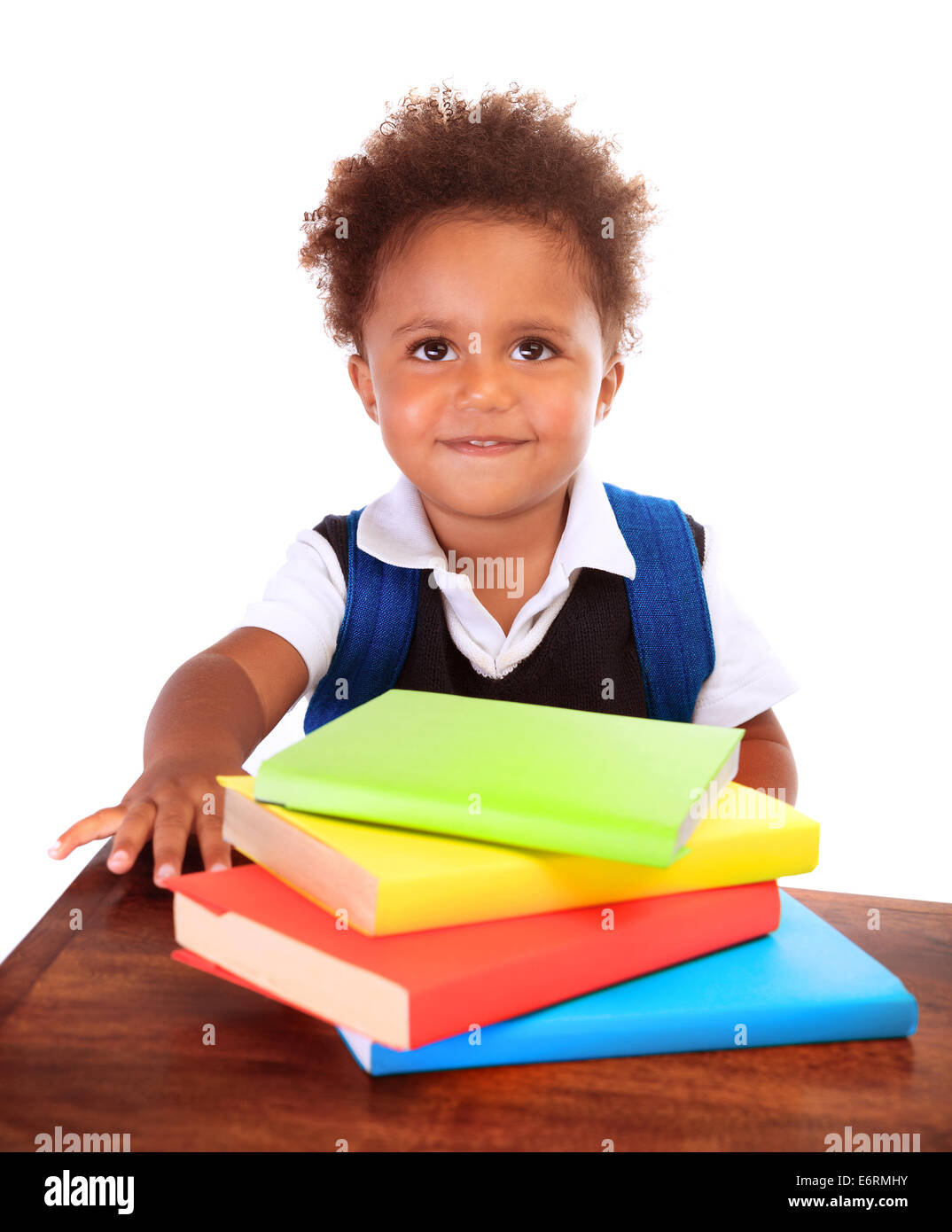 Glücklich afrikanischen Vorschulkind sitzen hinter Schreibtisch mit vielen Büchern drauf, isoliert auf weißem Hintergrund, Bildung und wissen Stockfoto