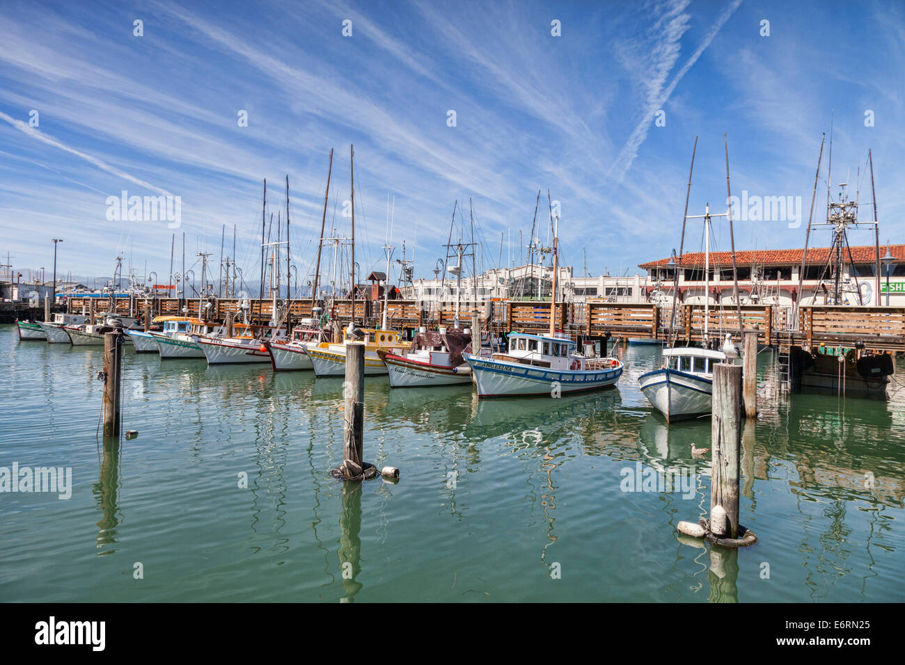 Boote am Fishermans Wharf, San Francisco, unter blauem Himmel voller Kondensstreifen. Stockfoto