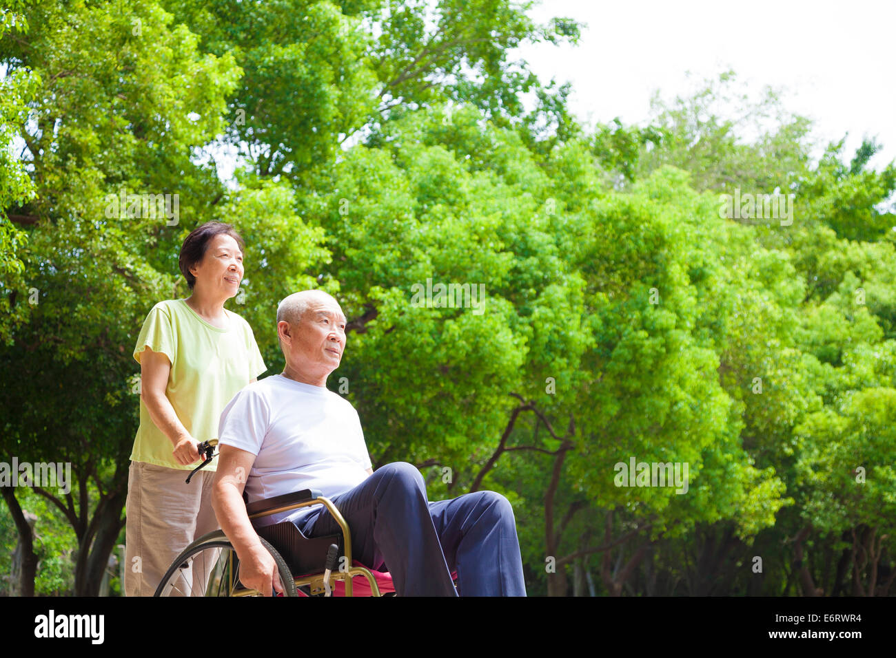 Asiatische senior Mann sitzt auf einem Rollstuhl mit seiner Frau Stockfoto