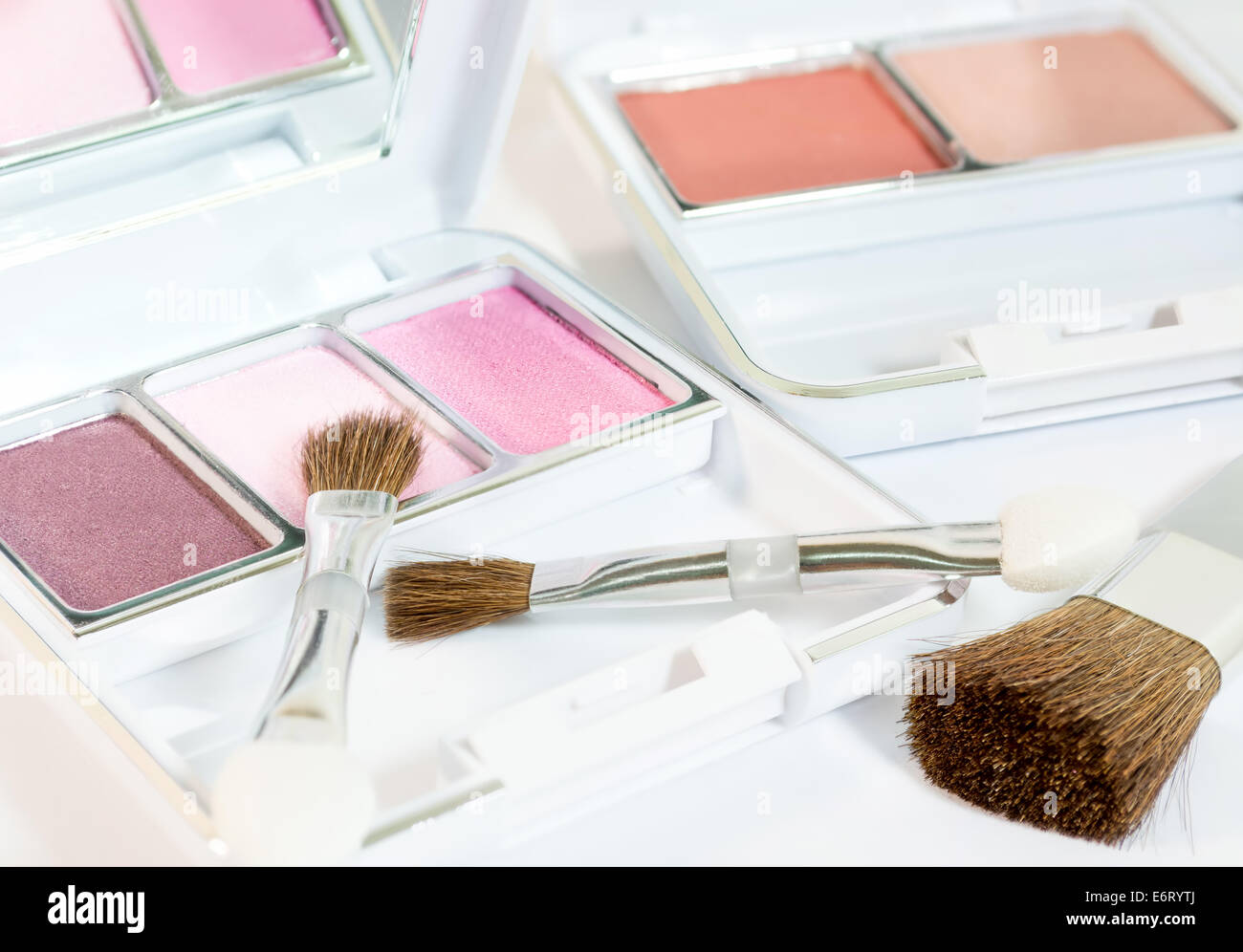 Make-up Produkte mit Augen Schatten, Bürsten und erröten in weißen Kosmetikbox mit Spiegel Stockfoto