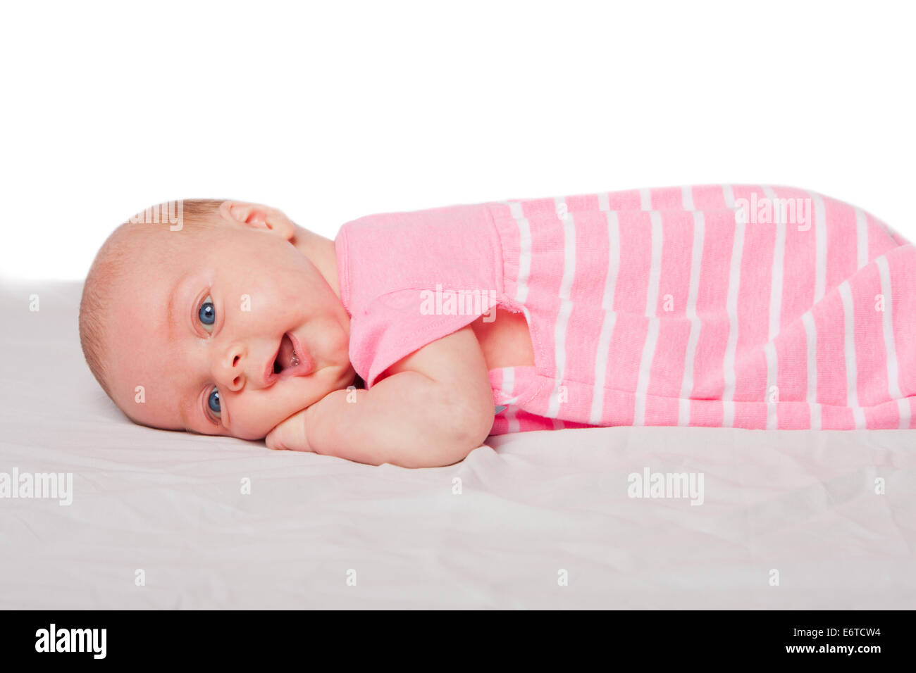 Niedliche glückliches Baby Kleinkind Mädchen Handauflegen Bauch Bauch auf weiß. Stockfoto