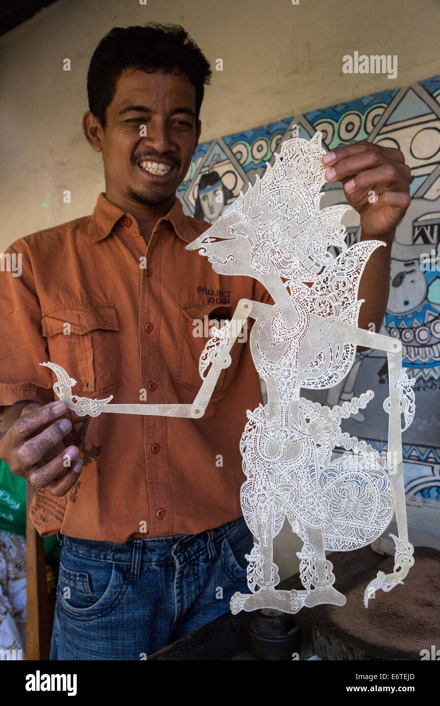 Yogyakarta, Java, Indonesien.  Javanischen Mann zeigt eine Muster für die Herstellung von Shadow Puppets. Stockfoto